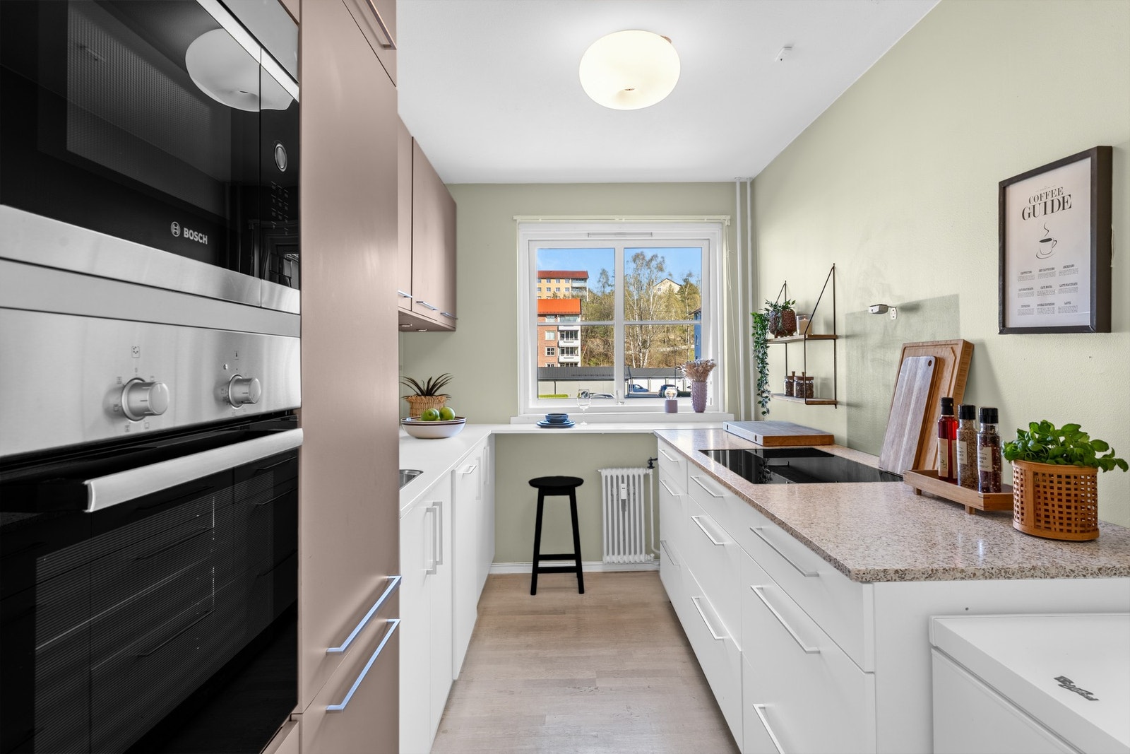 Kjøkkenet er moderne og praktisk med innredning fra KVIK, glatte fronter i hvitt og gråbrunt, og benkeplater i laminat og steinkompositt Galleribilde
