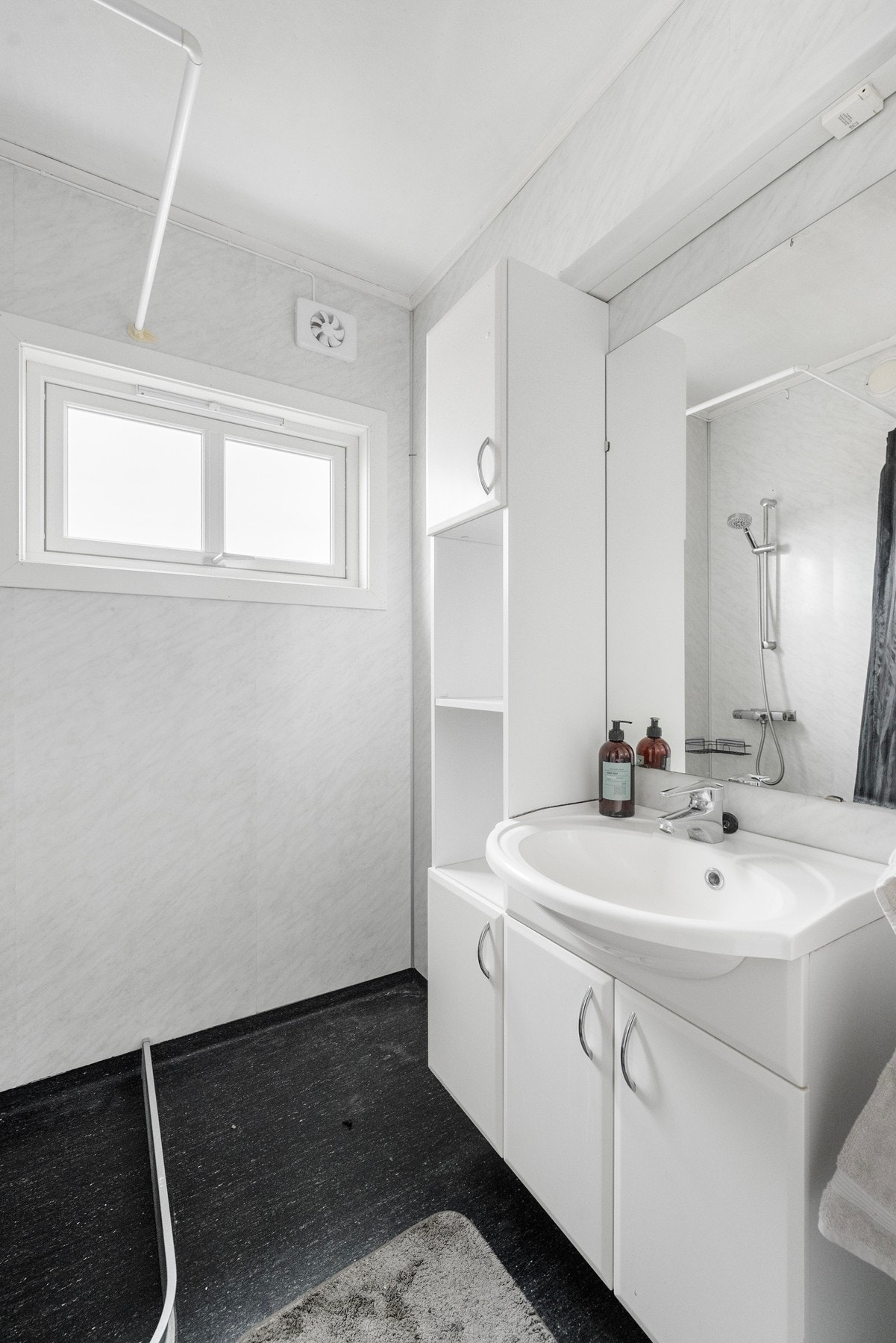 Badet har gulvbelegg, samt våtromsplater på veggene. Galleribilde