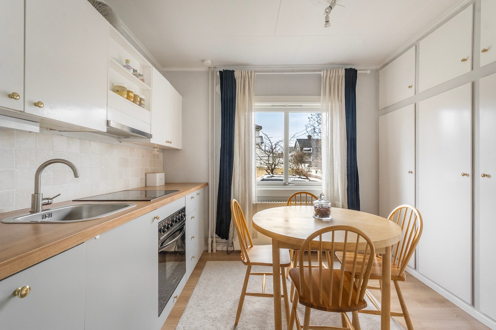 Leilighet nr. 1 har kjøkken lys innredning med slette fronter. Flis over benkeplate. Galleribilde