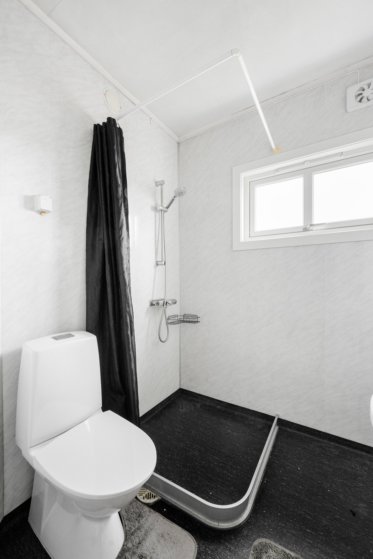 Badet er innredet med baderomsinnredning m/speil, dusj med forheng og gulvmontert wc. Oppvarming via stråleovn. Galleribilde