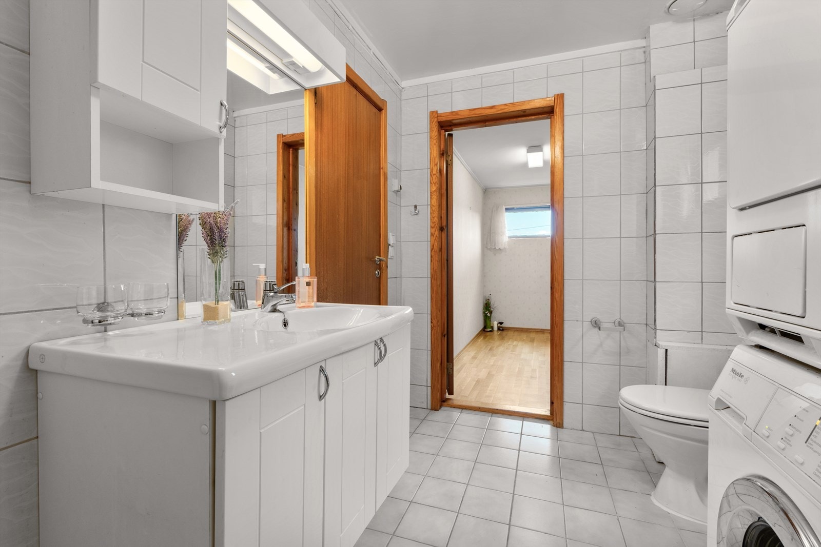 Badet har dusjkabinett, frittstående toalett, servantmøbel, varmtvannsbereder og opplegg for vaskemaskin og tørketrommel. Galleribilde