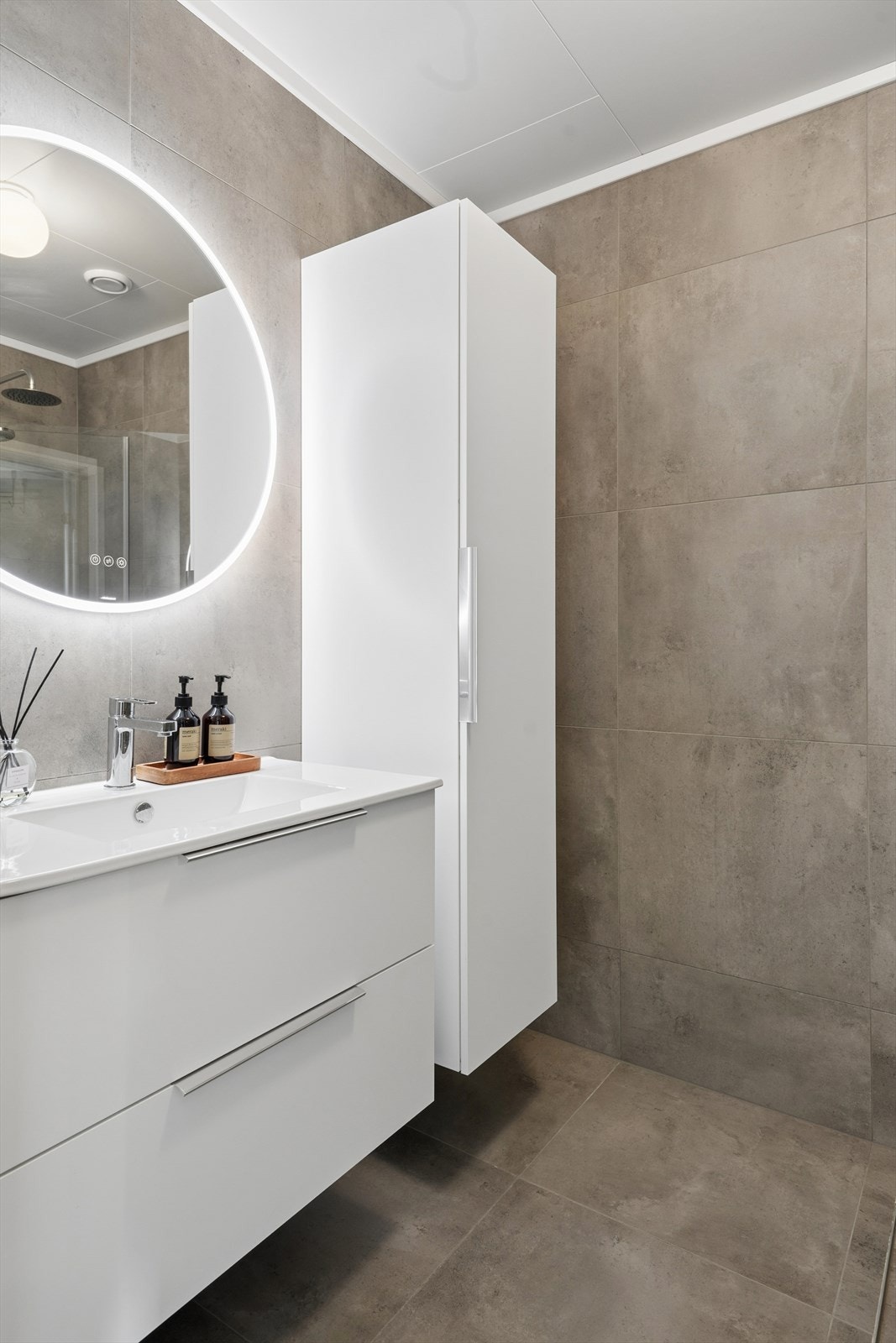 Rundt dimbart lysspeil med antidugg. Romslig baderomsinnredning for god oppbevaring Galleribilde