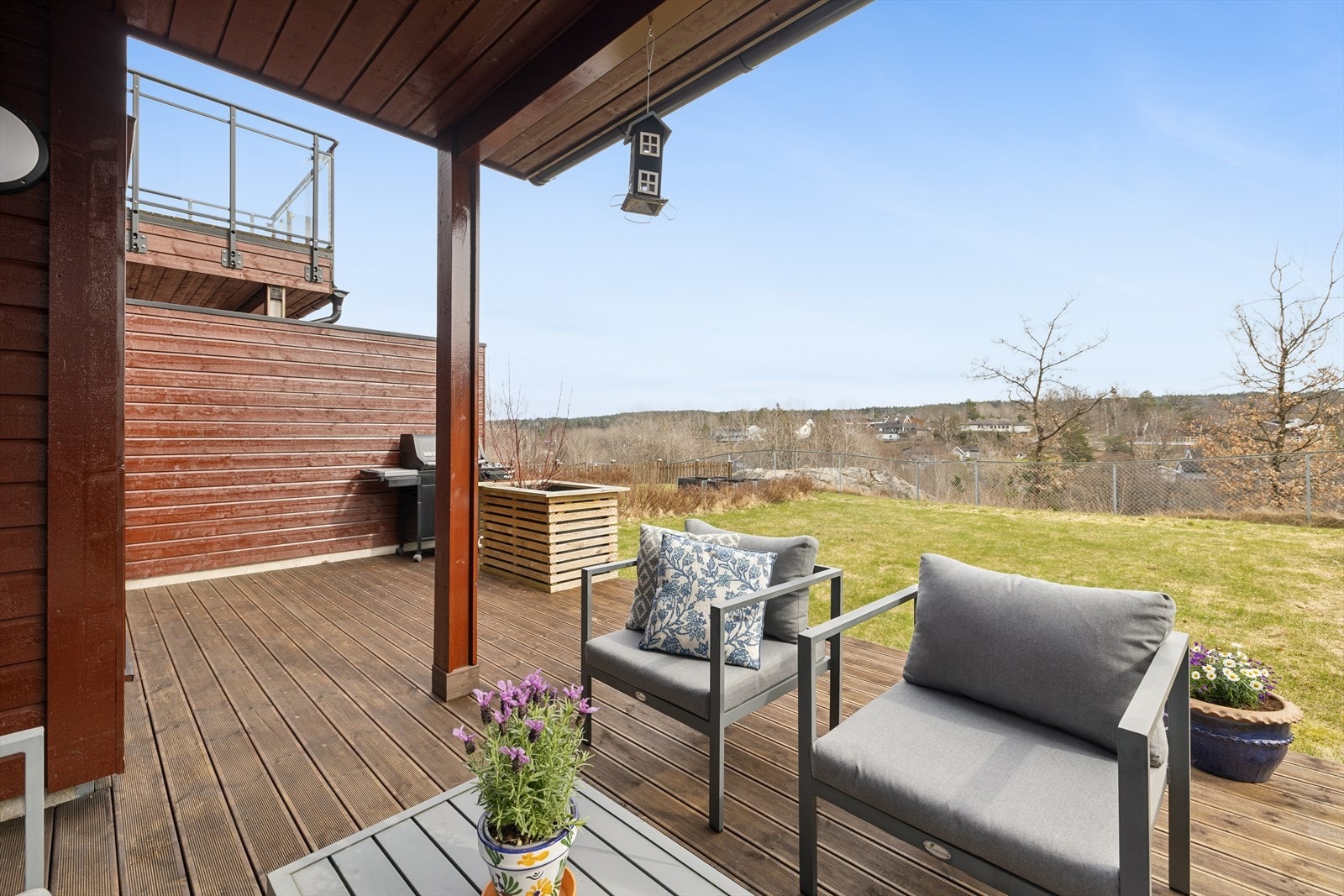 Uteplassen i underetasjen har beiset terrassebord og en åpen overgang til hagen. Galleribilde