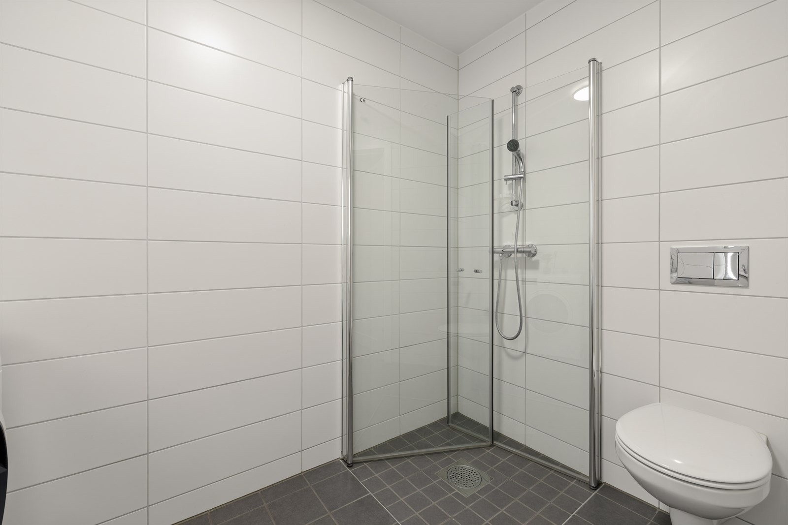 Dusjhjørne med innfellbare glassdører gir en arealeffektiv løsning på badet i underetasjen. Galleribilde