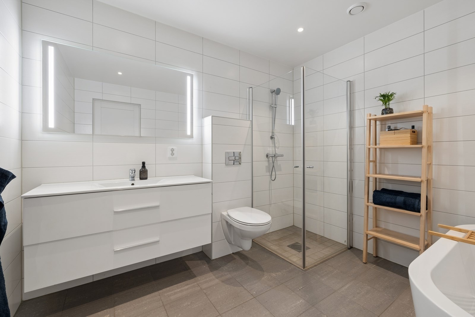 Badet i første etasje er fra byggeåret og utstyrt med både badekar og dusjhjørne med glassdører. Elektriske varmekabler i gulvet. Galleribilde