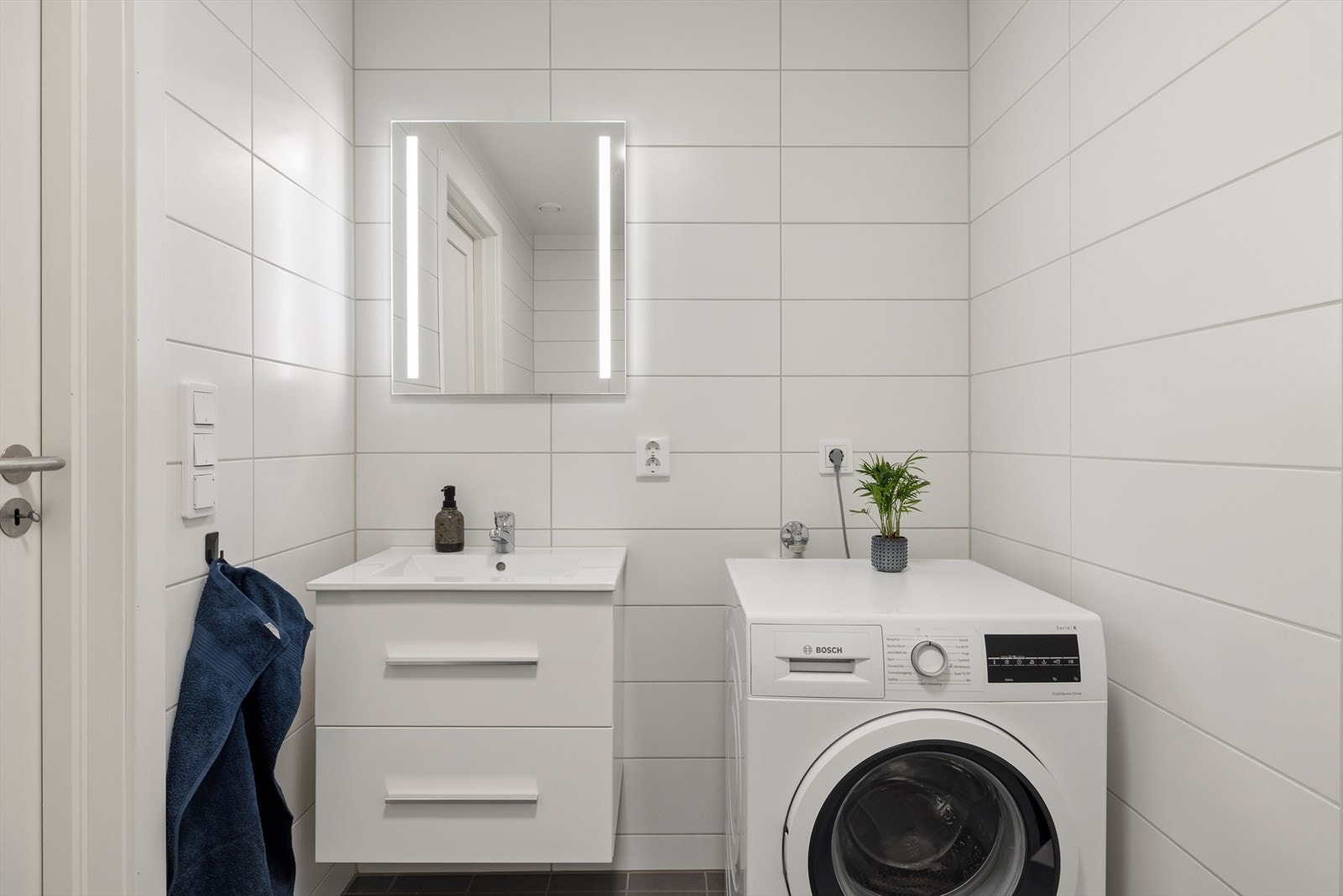 Badet i underetasjen har flislagt gulv med varmekabler, vegghengt toalett og opplegg for vaskemaskin. Galleribilde