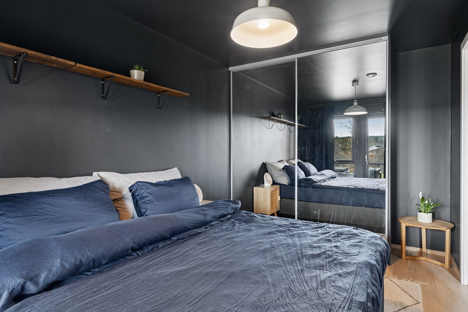 Det er god plass til oppbevaring på soverommet med en stor skyvedørsgarderobe med speilfronter. Galleribilde