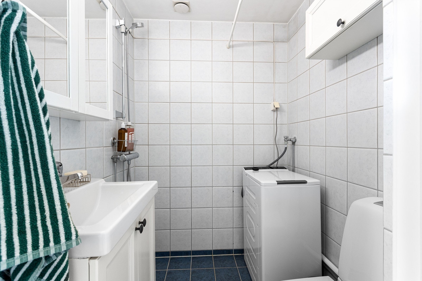 Badet er innredet med servant, speilskap, toalett og dusjhjørne. Galleribilde