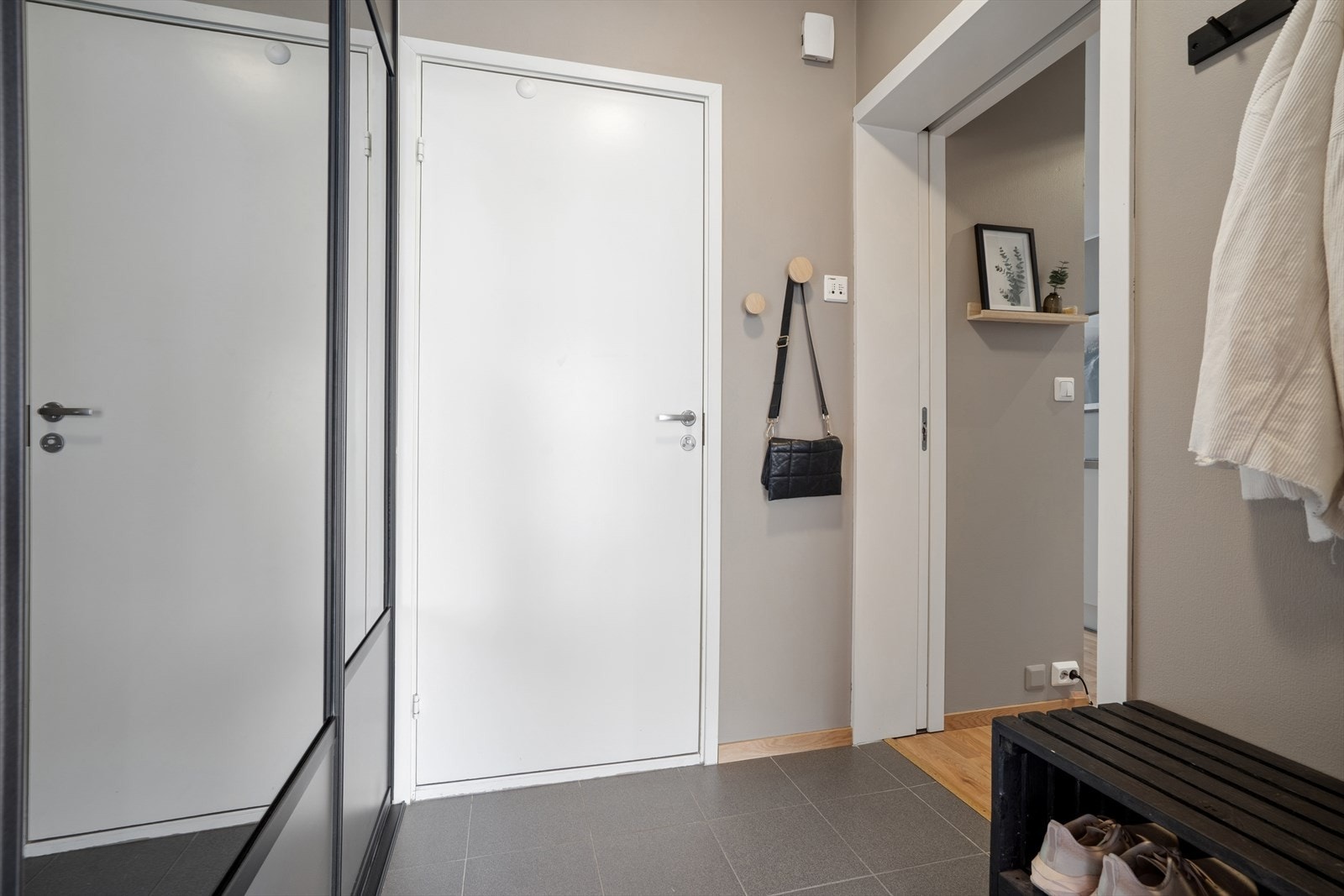 Entréen har flislagt gulv og skyvedørsgarderobe med speilfronter. Galleribilde