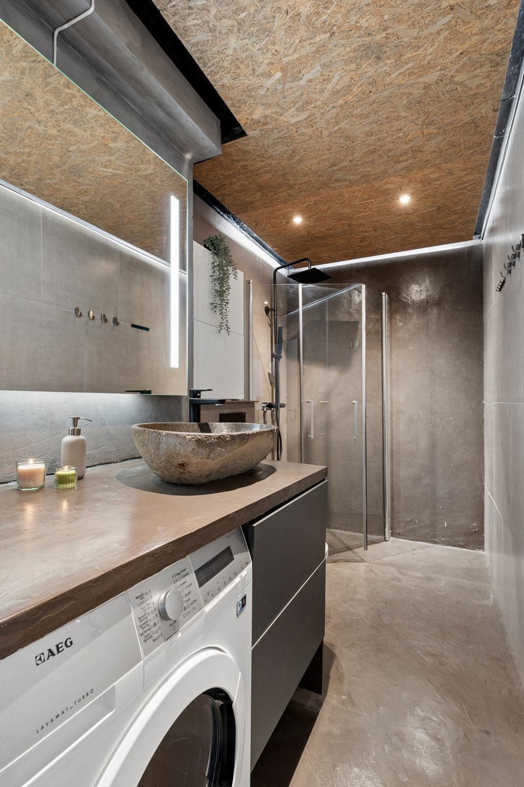 Badet ble pusset opp i 2020 med microsement på gulv og vegger, og en vegg med fliser. Himlingen har nedsenkede spotter. Galleribilde