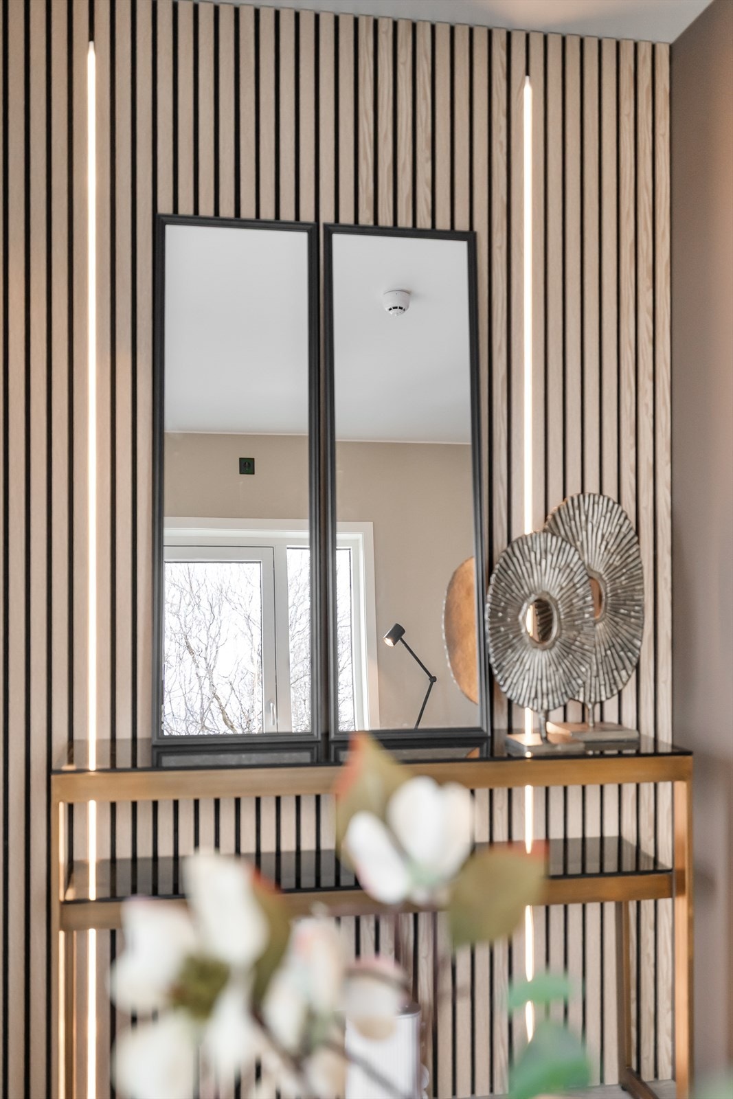 En elegant spilevegg med integrert belysning er et designelement som tilfører varme og karakter til rommet. Galleribilde