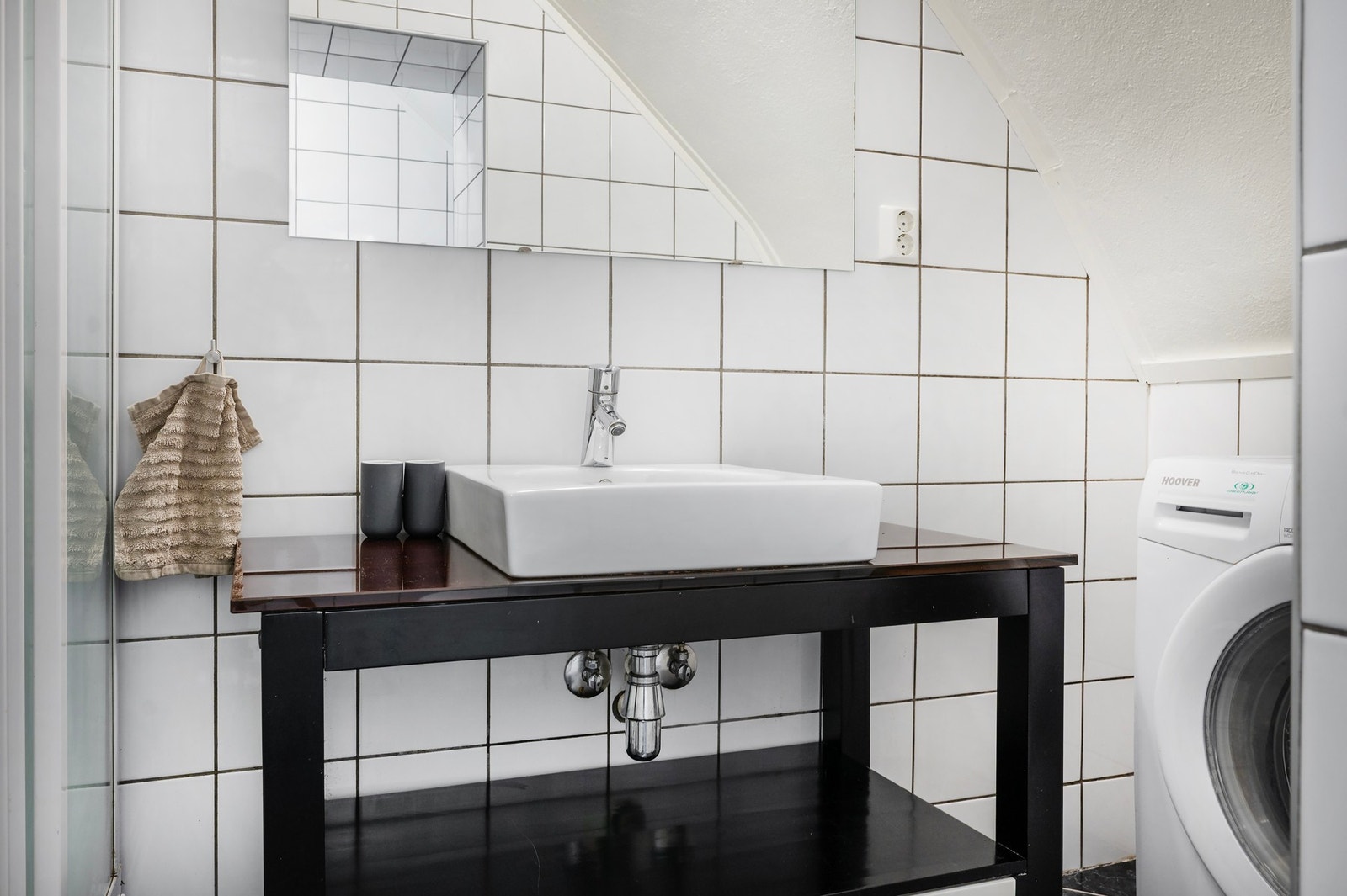 Rommet har innredning med nedfelt servant og opplegg for vaskemaskin. Galleribilde