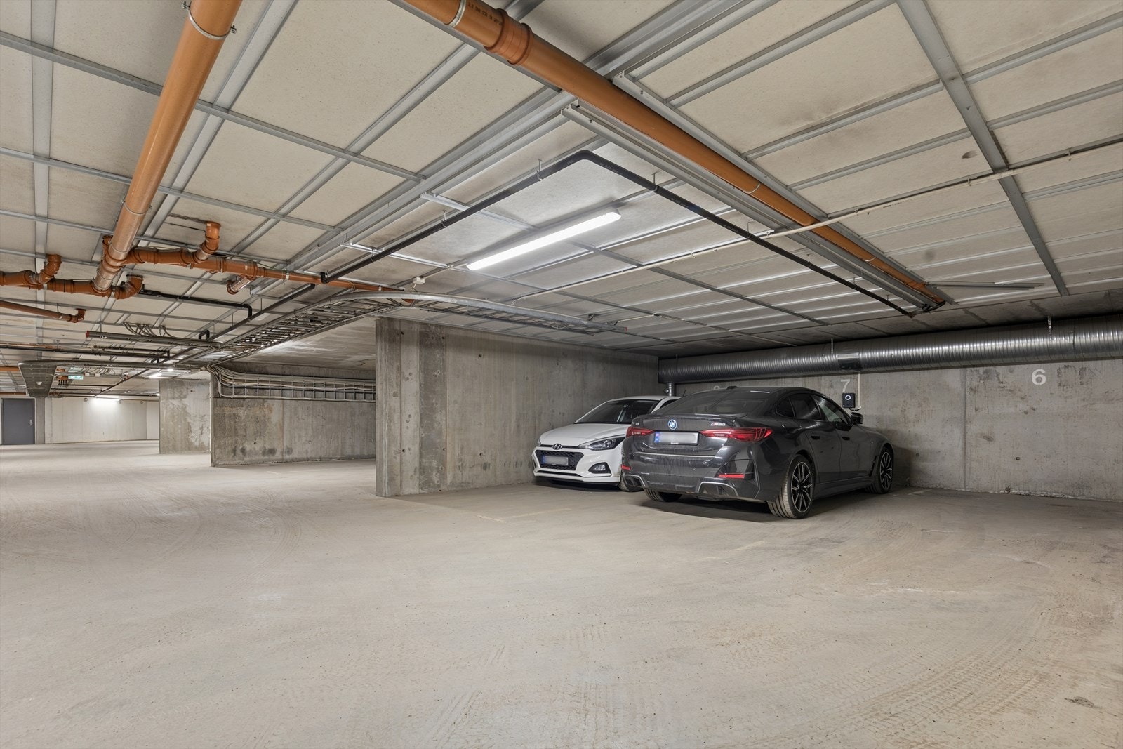 Det medfølger en tilhørende parkeringsplass (plass 7) for én bil i felles parkeringskjeller, hvor det er tilrettelagt for el-billader, med heisadkomst. Galleribilde