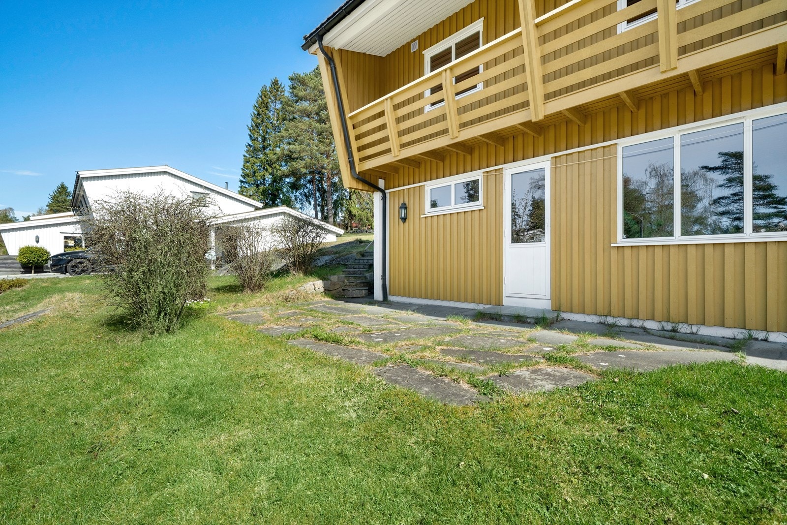 Det er utgang til markterrasse og hage fra stuen i underetasje Galleribilde