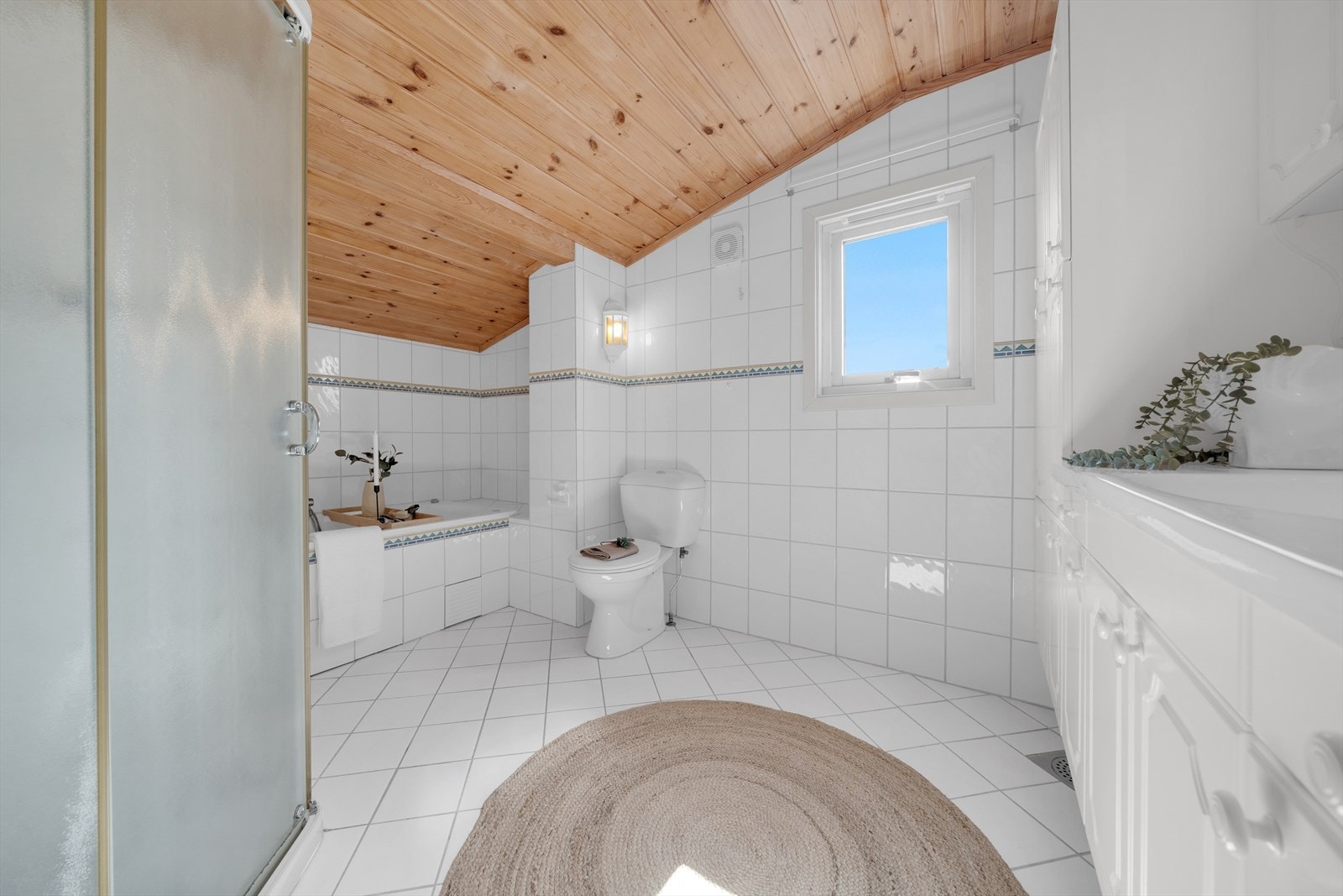 Baderom fra 1998 med både dusj og badekar. Det er WC og servant, servant skap og speil Galleribilde
