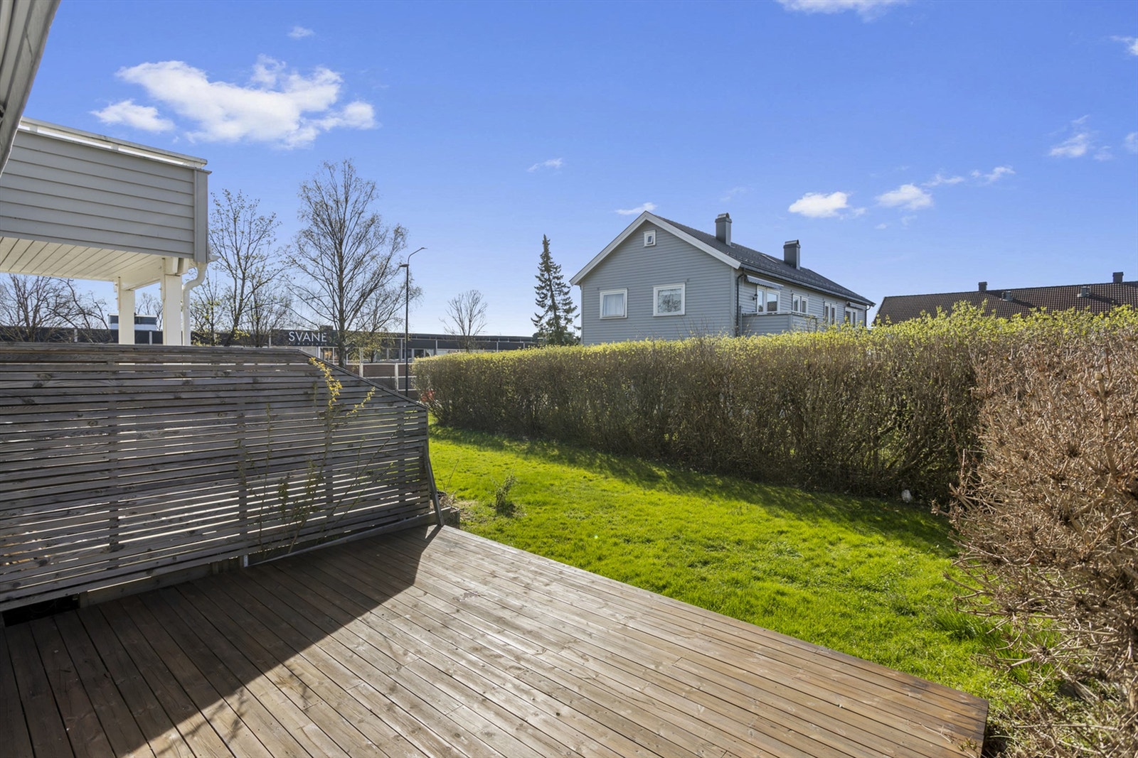 Uteplassen er skjermet og privat, med en hekk som rammer inn hagen. Galleribilde