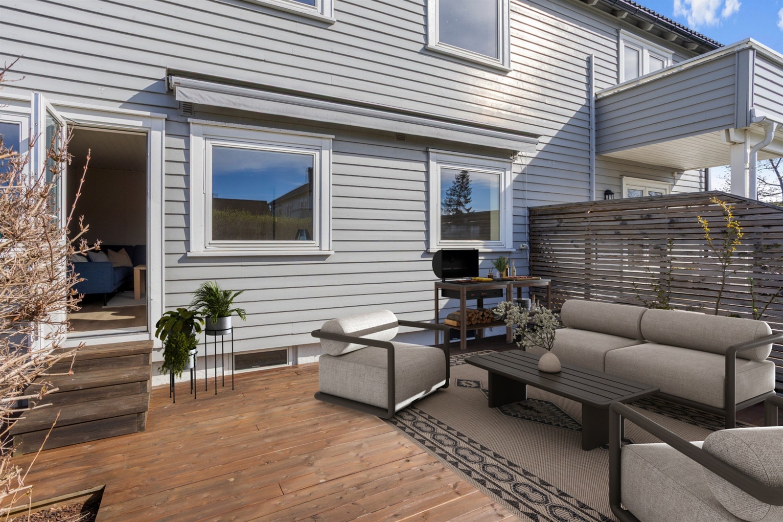 Fra stuen er det direkte utgang til en stor, vestvendt terrasse på over 24 m², med god plass til utemøbler. (KI redigert bilde) Galleribilde