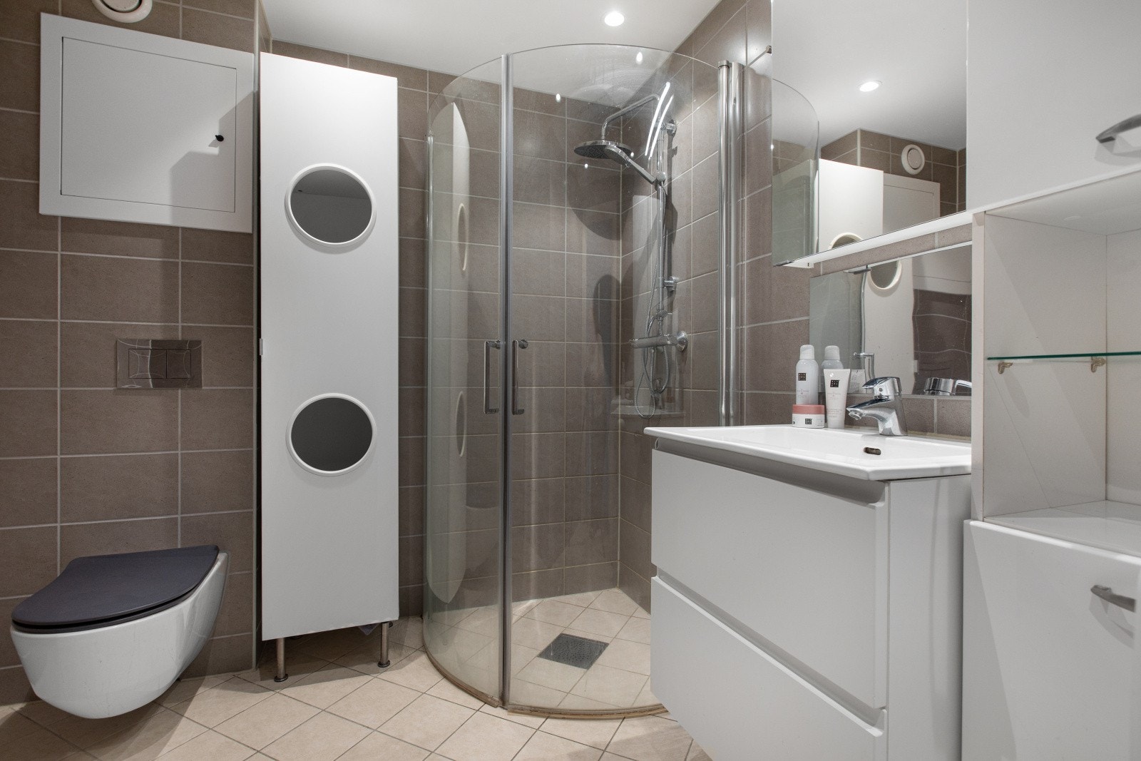 Flislagt og delikat baderom med gulvvarme og downlights som bidrar til ekstra komfort. Badet ble oppgradert i regi av borettslaget i 2019. Galleribilde
