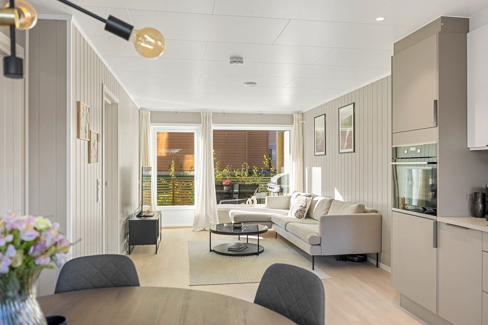 Lys stue med store vindusflater og utgang til terrassen. Galleribilde