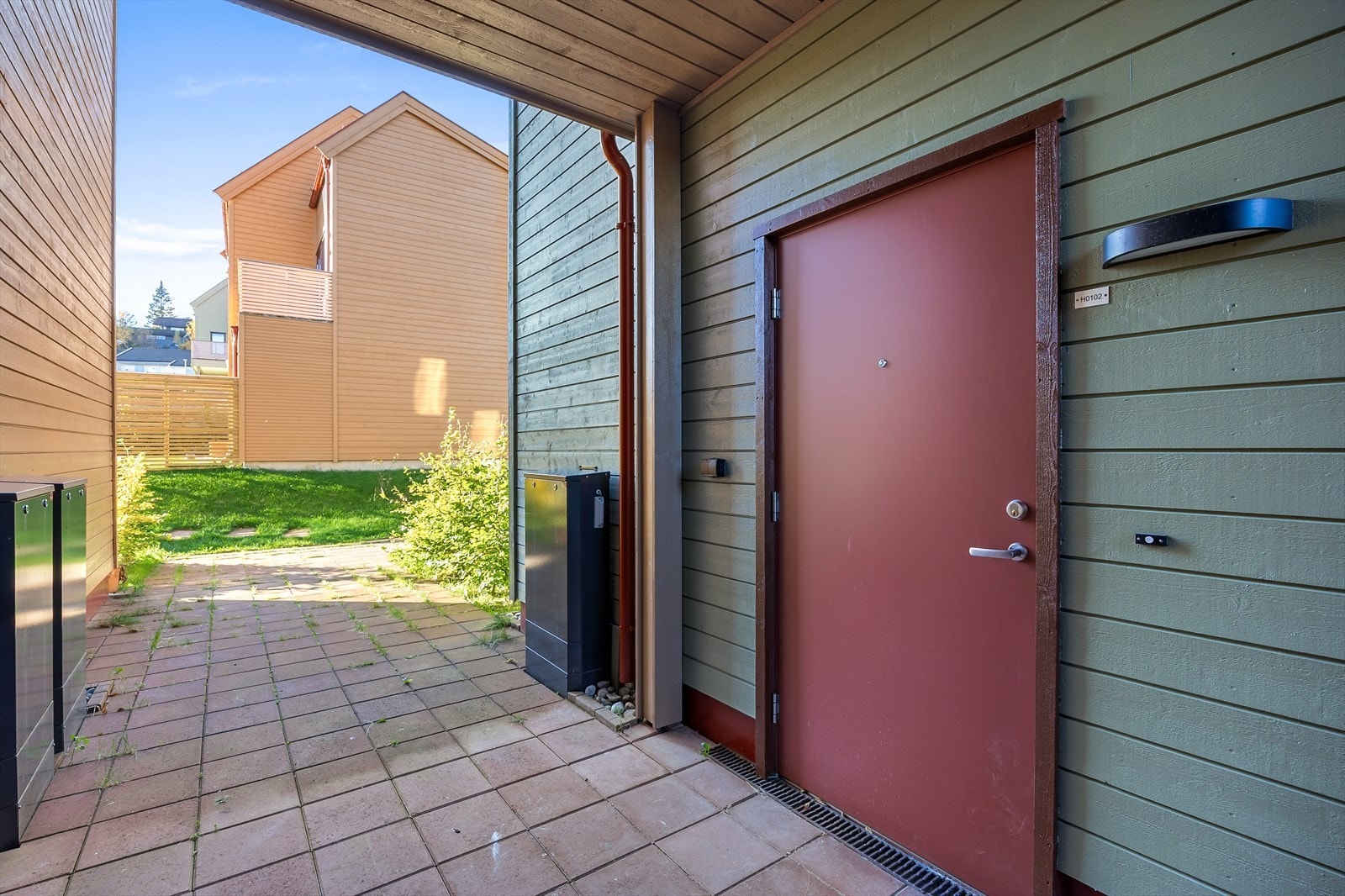 Overbygget inngangsparti til leiligheten fra bakkeplan. Velkommen inn! Galleribilde