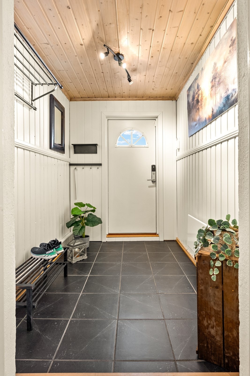 Flislagt entré med plass til å henge fra seg yttertøy og sko. Galleribilde