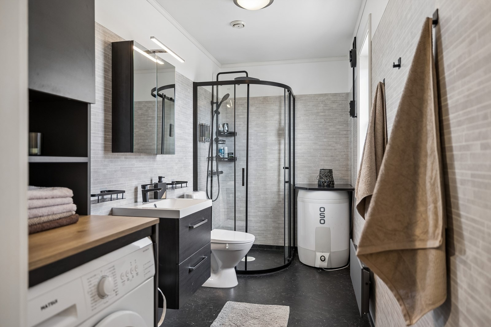 Badet er nytt i 2024, oppgradert etter en tidligere vannskade. Rommet har dusjvegger og opplegg for vaskemaskin. Galleribilde