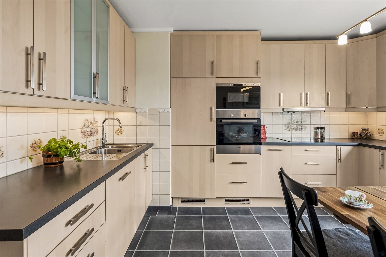 Rommet har en eldre IKEA-innredning med glatte fronter og enkelte fronter med frosta glass. Galleribilde