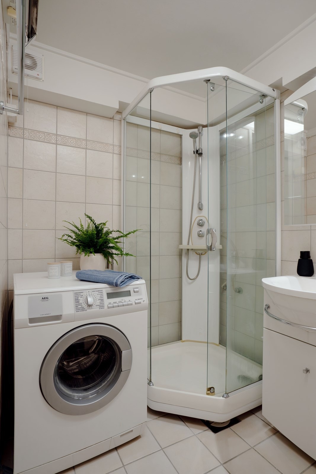 Badet er innredet med dusjkabinett, servant med innredning, opplegg for vask og tørk. Galleribilde