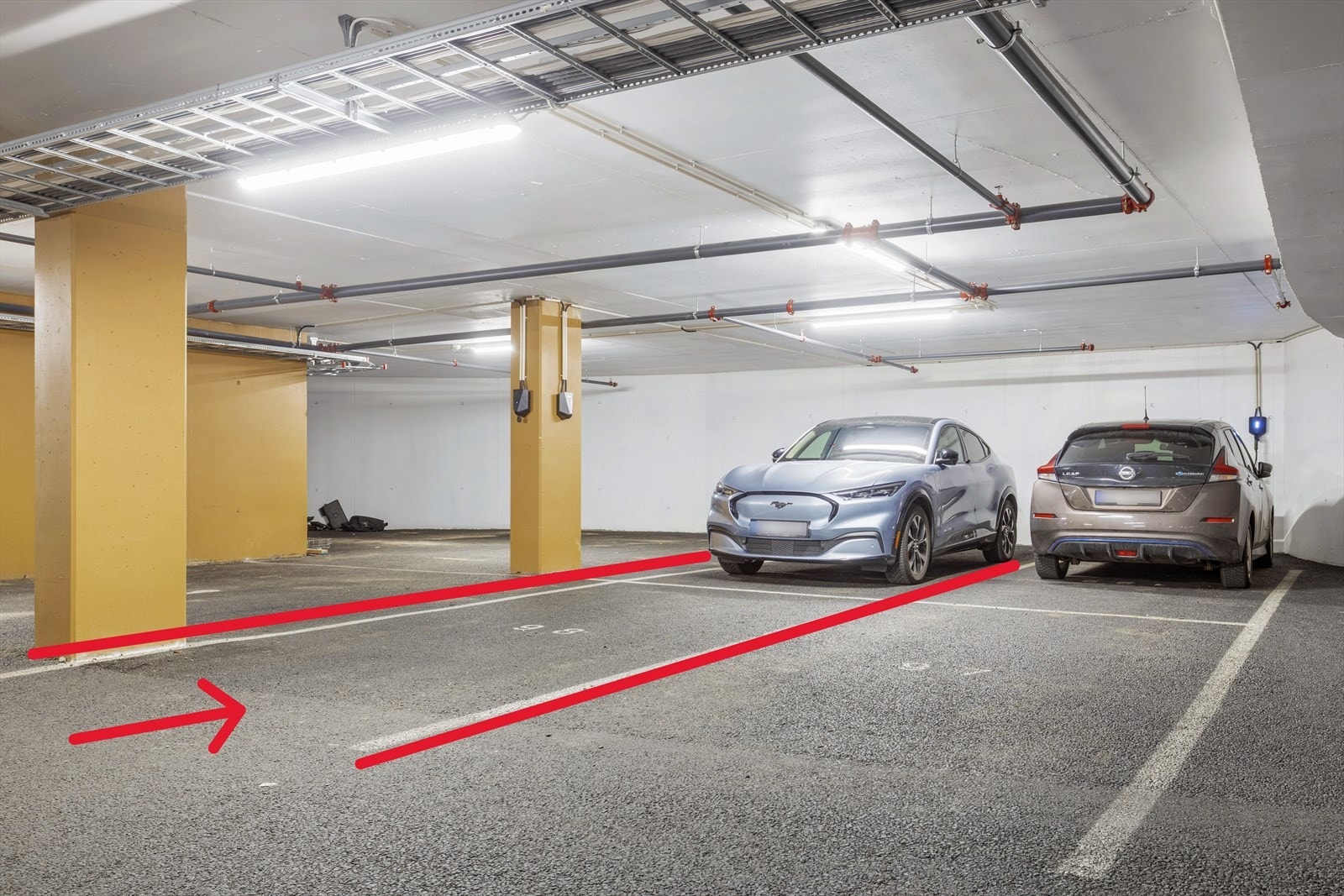 Dobbel parkeringsplass med elbillader plassert i midten. Galleribilde