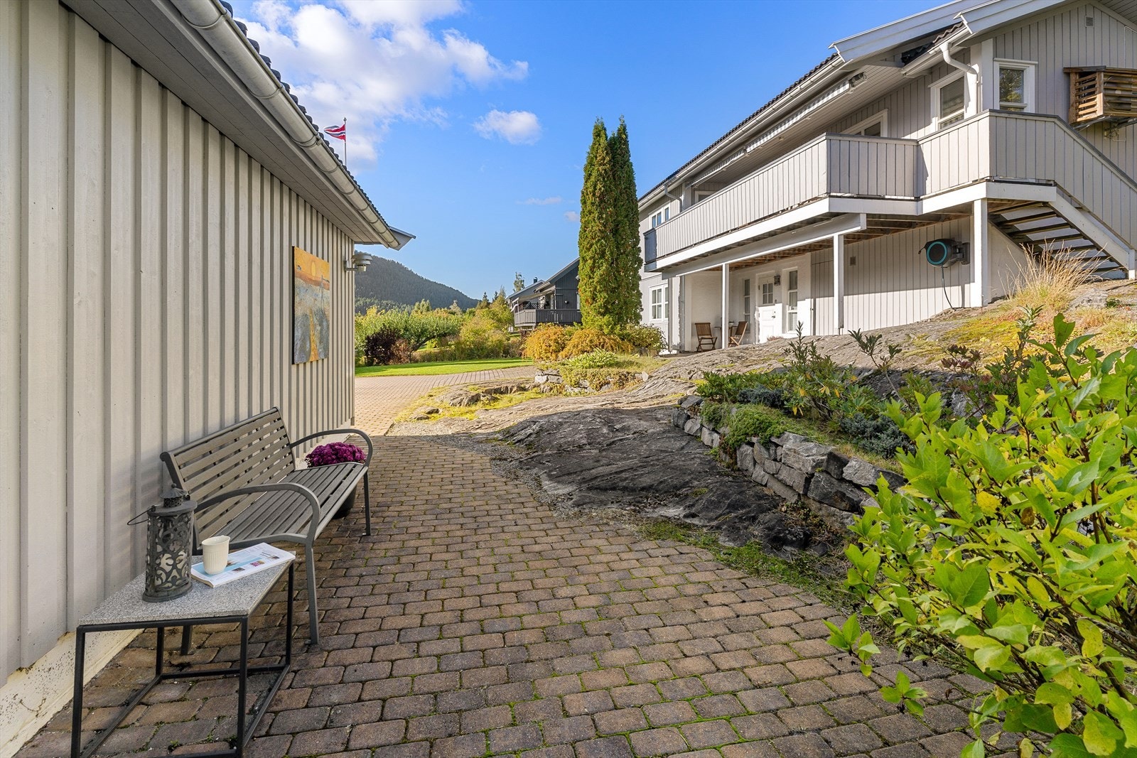 Gårdsplassen er pent anlagt med belegningsstein, som også går rundt deler av garasjen og huset. Galleribilde