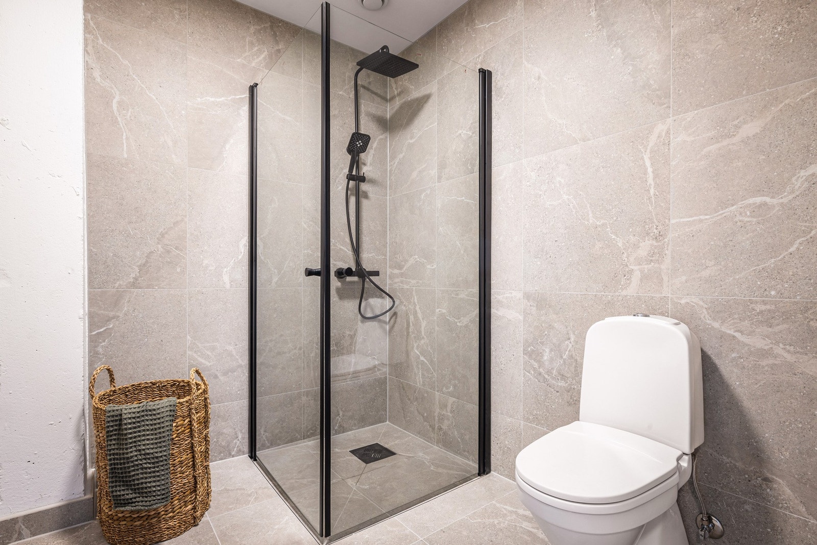 - Badet som måler 5 m² har storformat fliser på gulv og vegger og varmekabler i gulv - Galleribilde