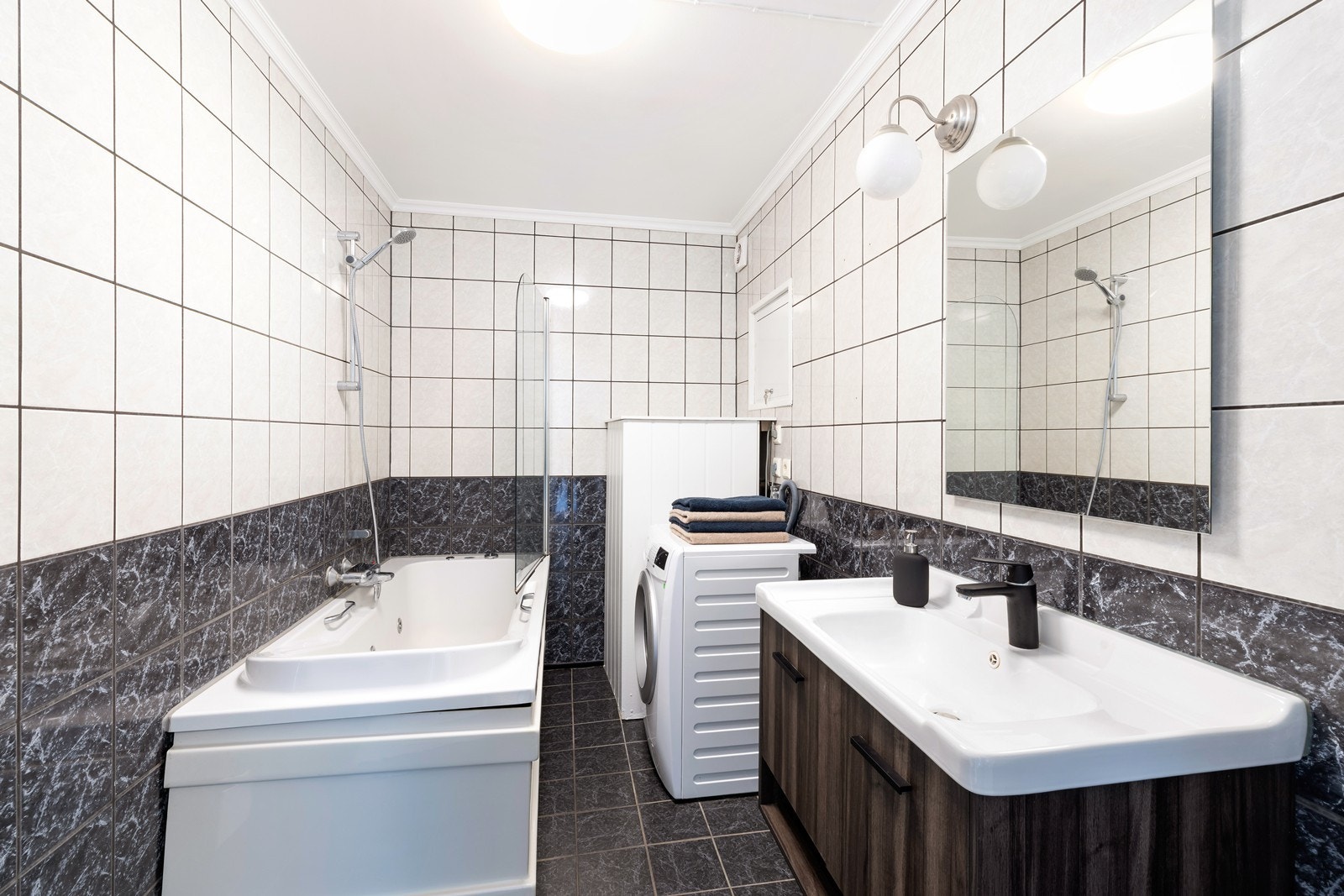 Flislagt baderom med varmekabler i gulv. På baderommet er det badekar med dusj, toalett, servant med underskap og overspeil samt oppbevaring. Det er opplegg for vaskemaskin på baderom. Galleribilde