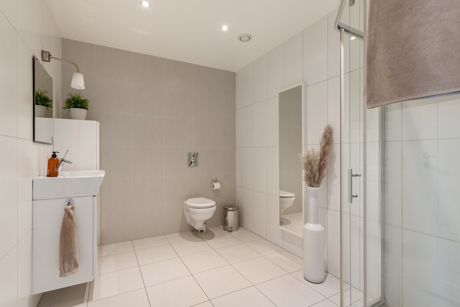 Helfliset baderom med vannbåren gulvvarme som gir behagelig komfort. Badet er stilrent innredet med nedfelt servant, vegghengt toalett og dusjhjørne med glassvegger Galleribilde