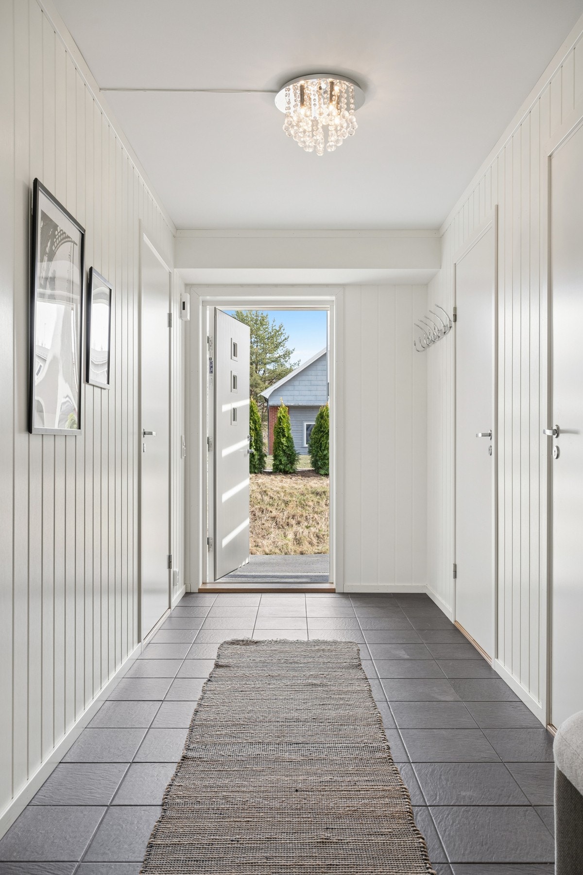 Her kommer du inn til en flislagt entré med plass til å hensette sko og yttertøy. Galleribilde