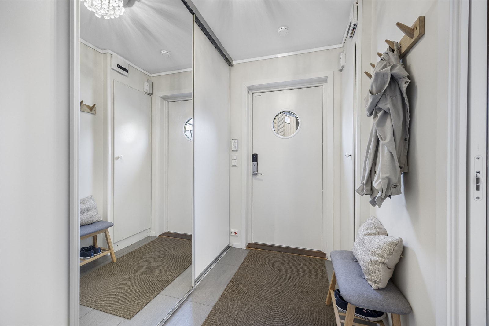 Entréen har flislagt gulv med varmekabler og god oppbevaringsplass i skyvedørsgarderobe. Galleribilde