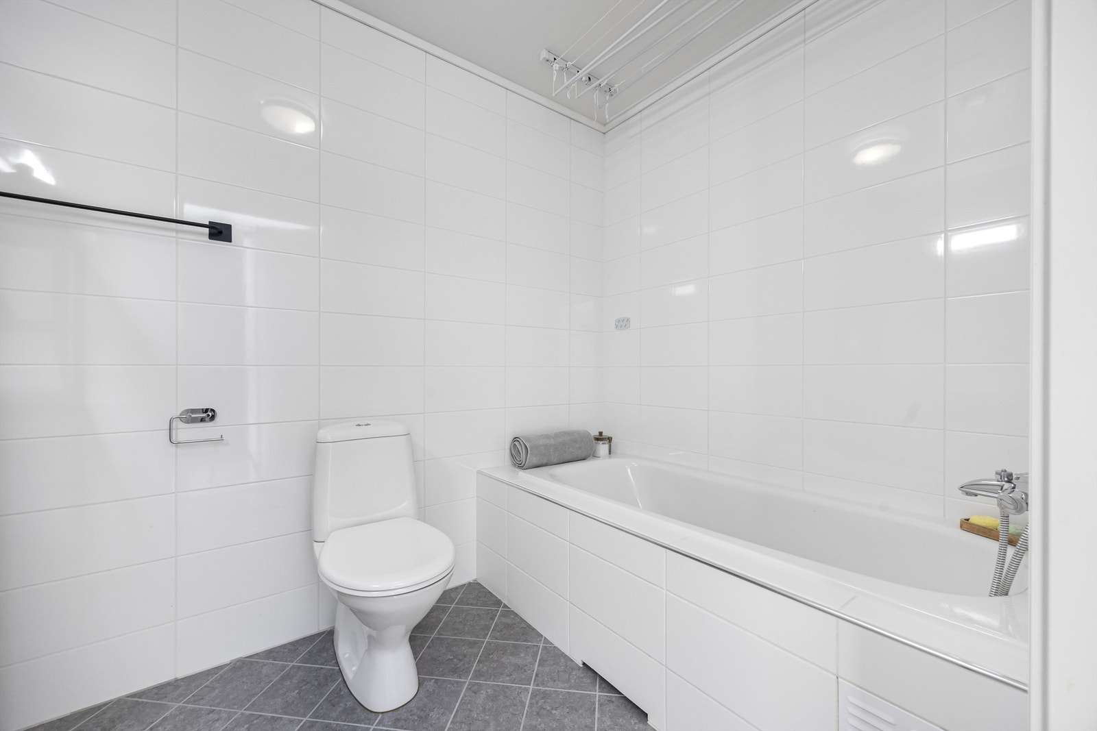 Badet i andre etasje er utstyrt med badekar, flislagt gulv med varmekabler, servantinnredning og gulvstående toalett. Galleribilde