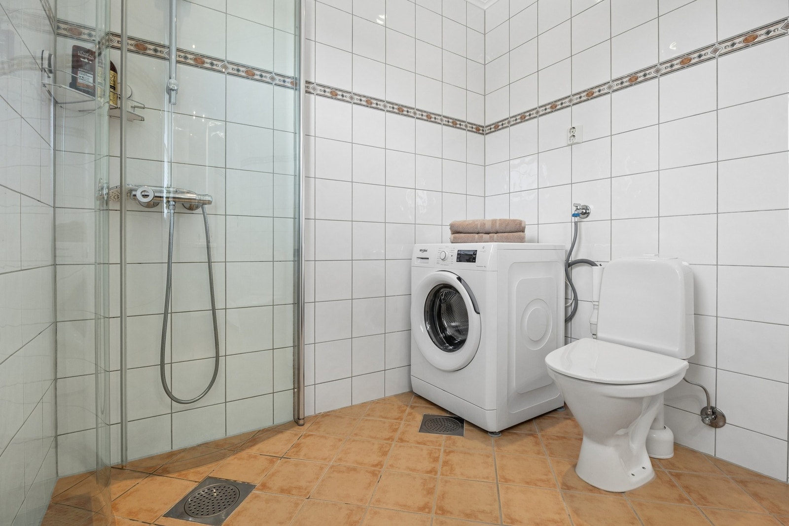 Badet har dusjhjørne med glassdører, opplegg for vaskemaskin og
gulvstående toalett. Galleribilde
