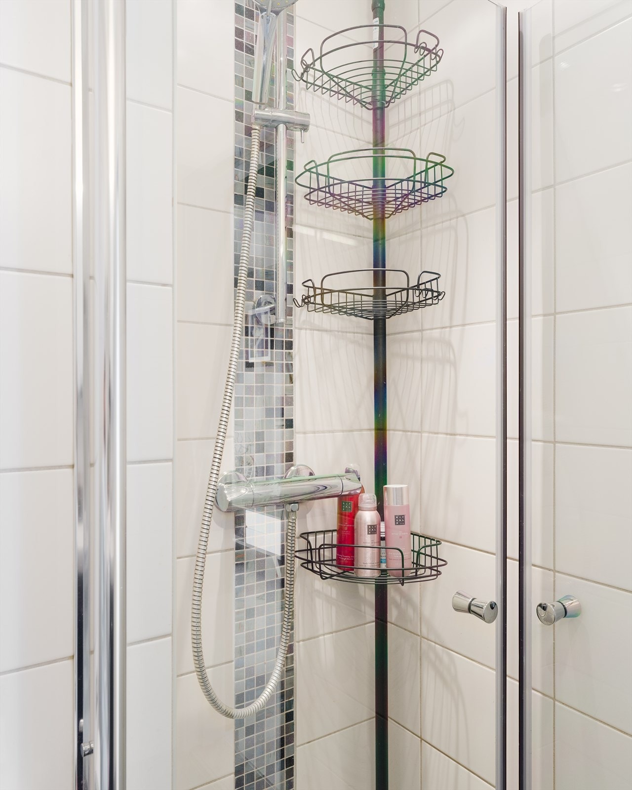Badet er utstyrt med gulvmontert toalett og dusjhjørne med rette glassdører. Galleribilde