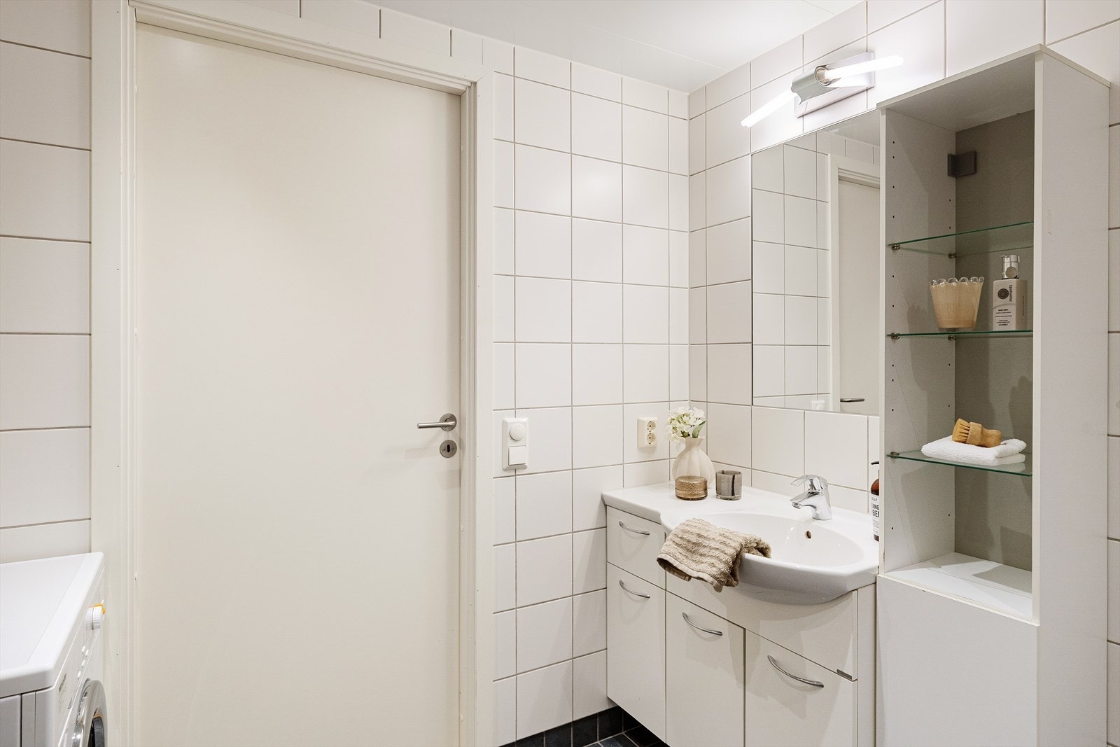 Badet har en praktisk innredning med servantseksjon og høyskap for god oppbevaring. Galleribilde