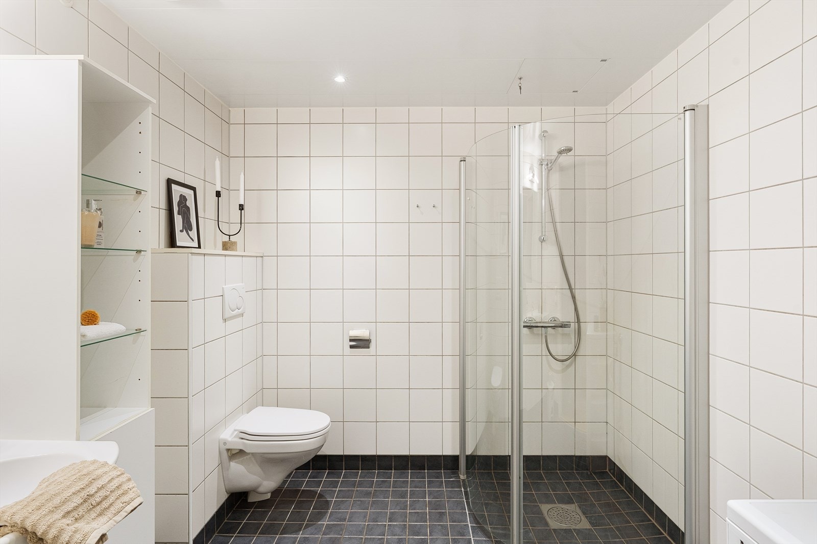 Helfliset bad med vannbåren gulvvarme, vegghengt toalett og opplegg for vaskemaskin. Dusjsonen har innfellbare glassdører. Galleribilde