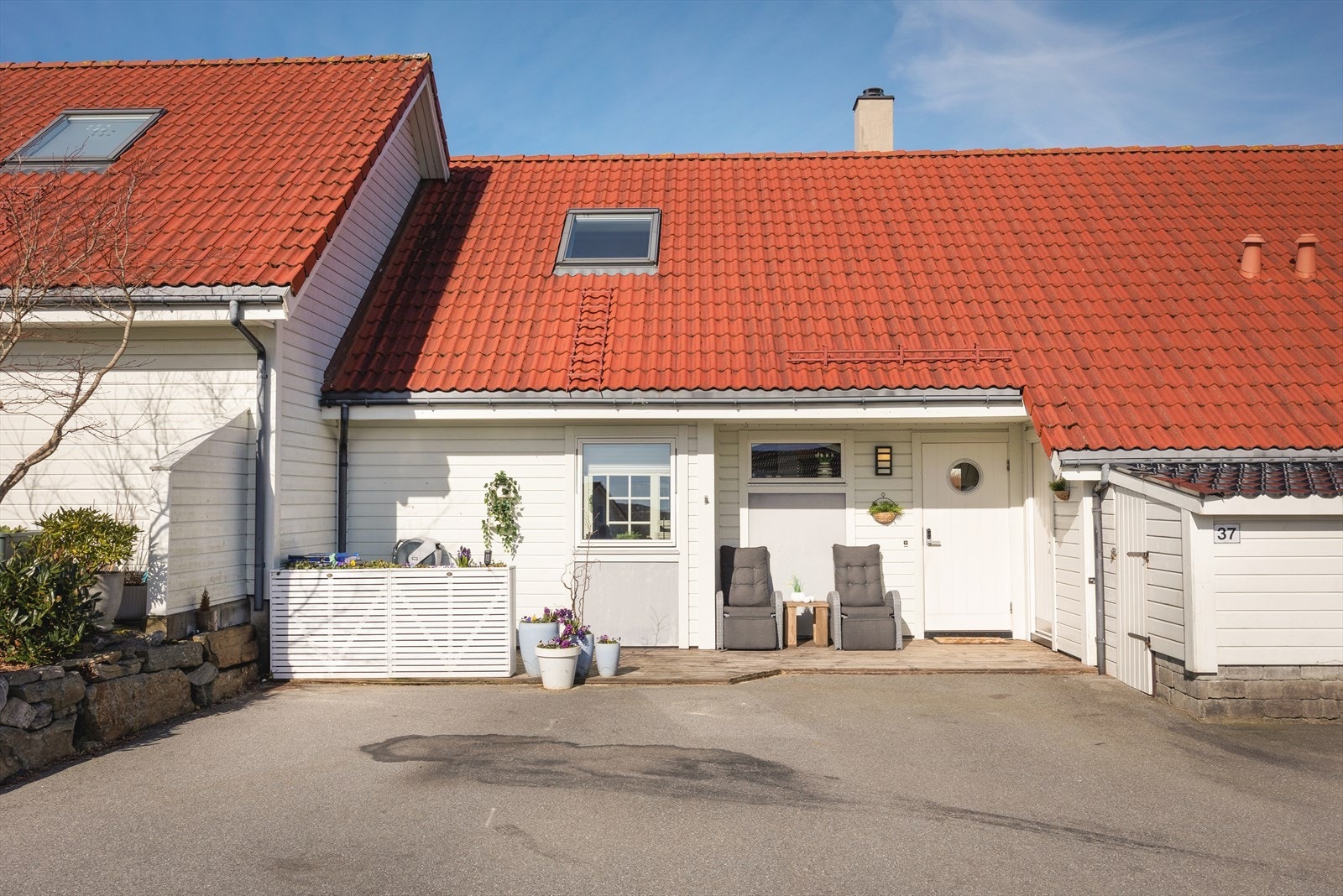 Boligens inngangsparti med parkeringsplass for tre biler. Galleribilde