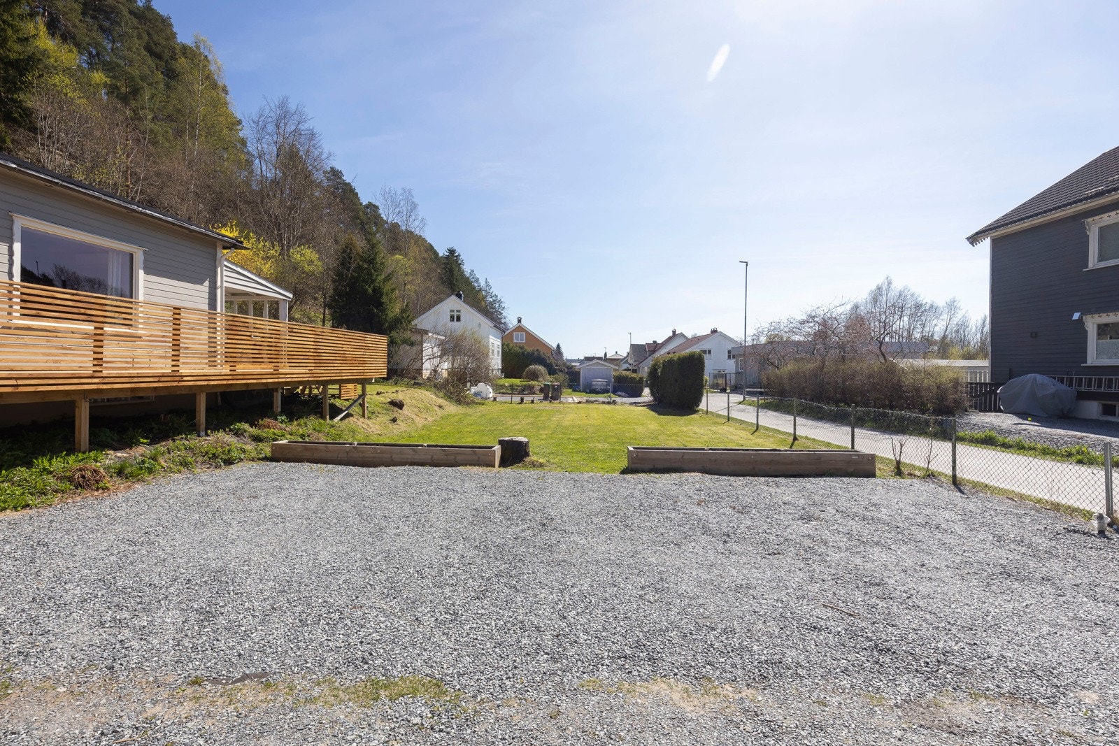 Stor gruset gårdsplass med god plass til flere biler Galleribilde