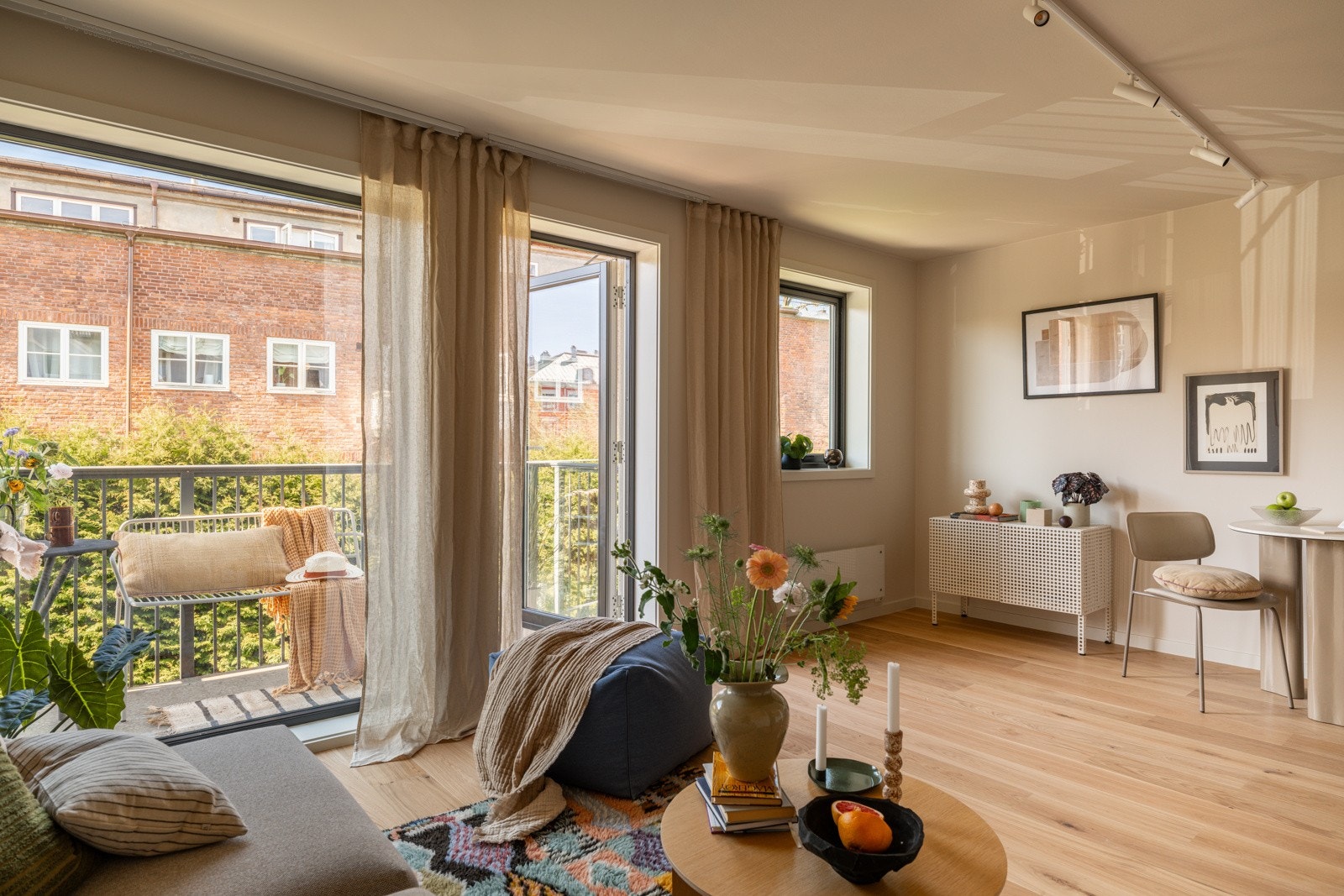 Stuen har store vinduer som slipper inn rikelig med naturlig lys, samtidig som en stor hekk hindrer innsyn. Galleribilde