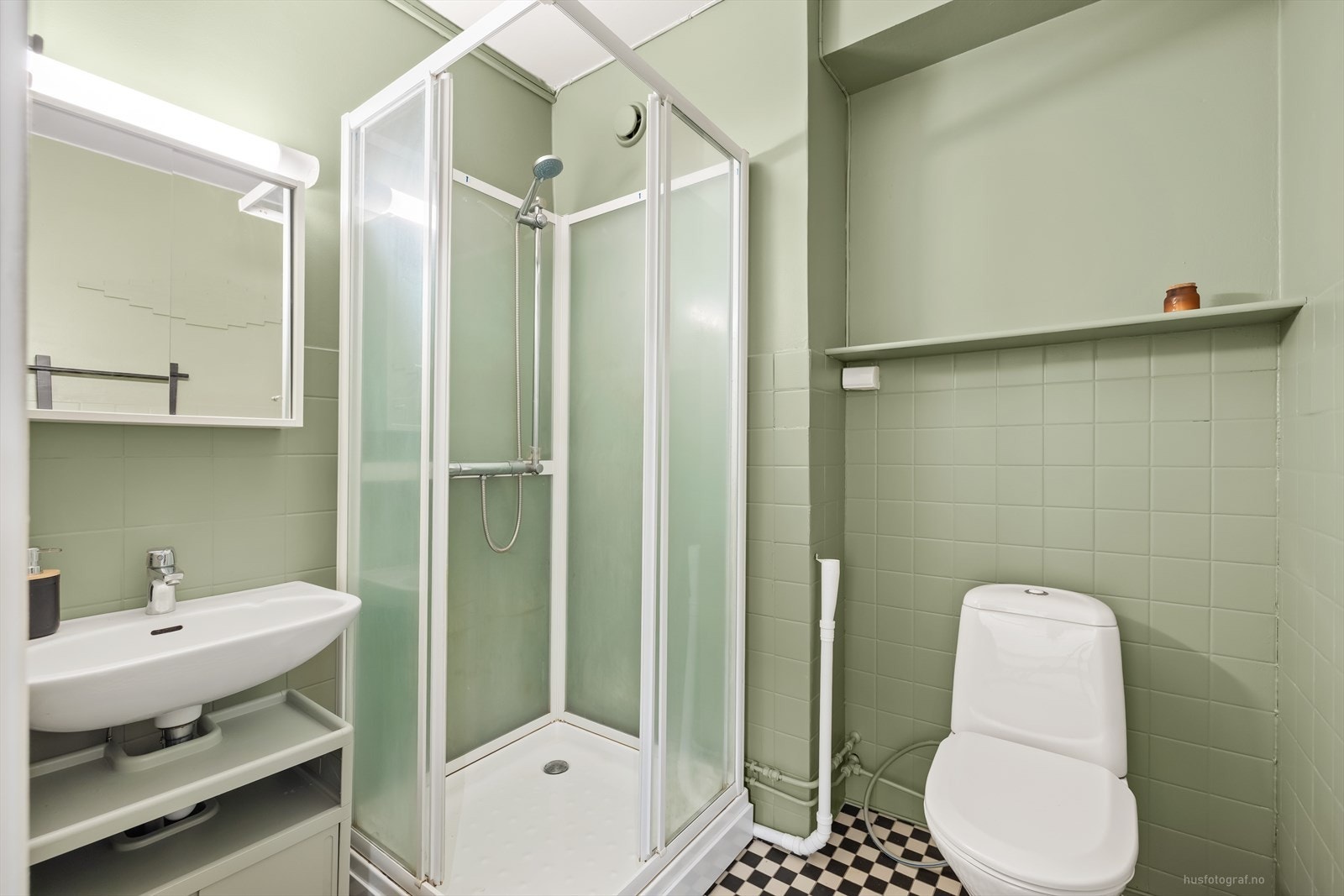 På badet er det montert et dusjkarnapp, et toalett, en servant og det er opplegg for vaskemaskin. Galleribilde