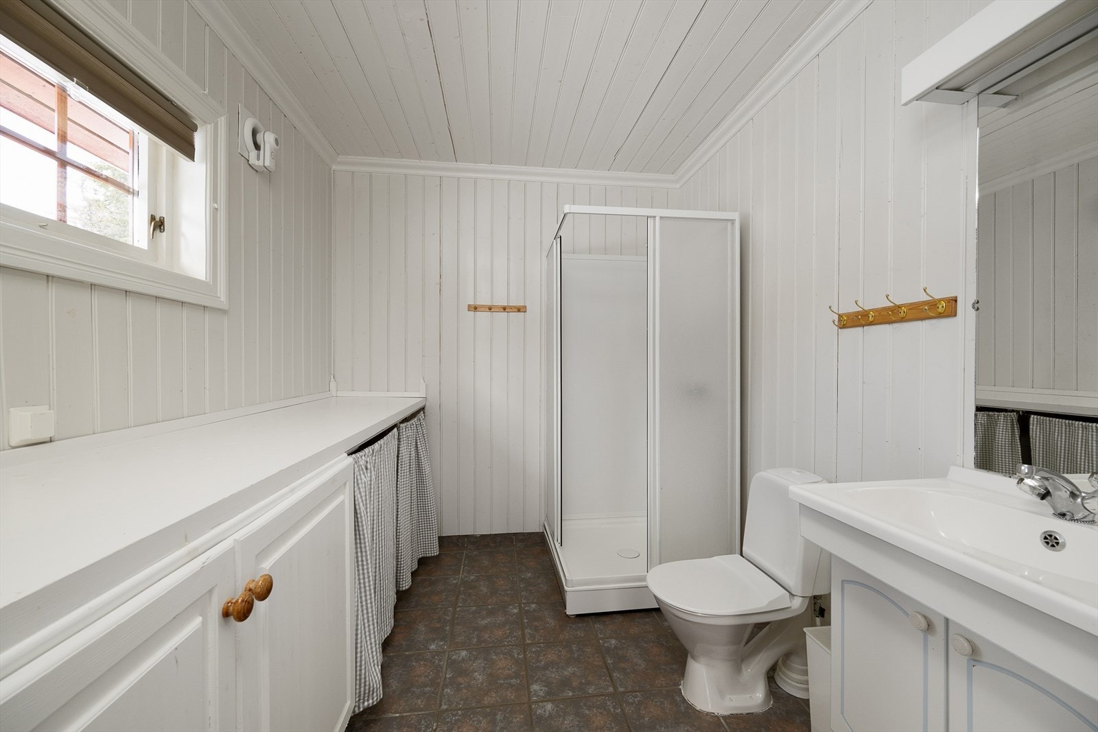 Badet i hovedhytta har flislagt gulv med varmekabler og opplegg for vaskemaskin. Galleribilde