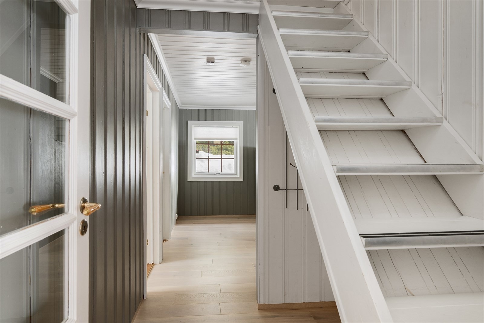 En malt heltre trapp fører opp til hemsen. Galleribilde