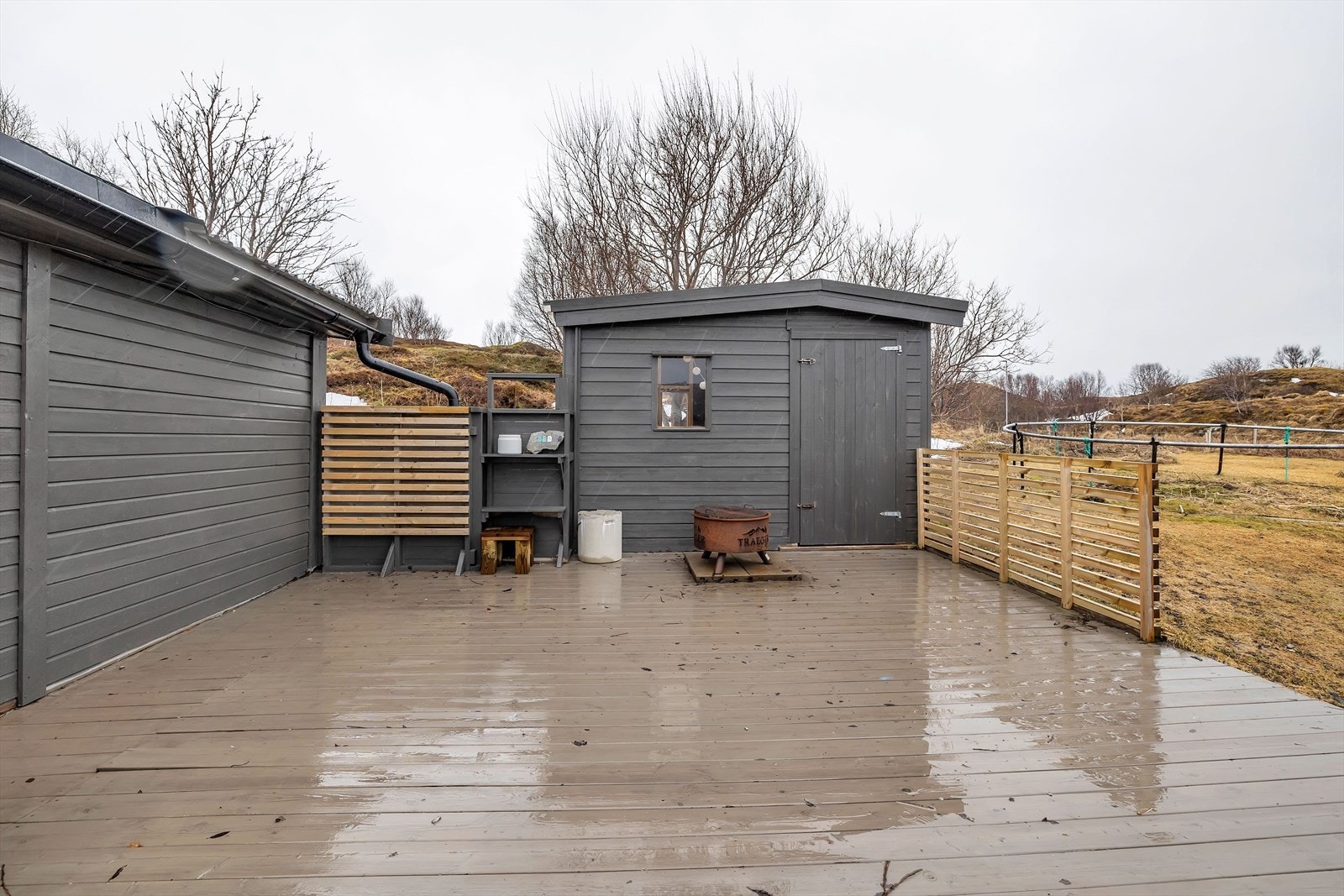 Uteareal med to uthus og terrasser Galleribilde
