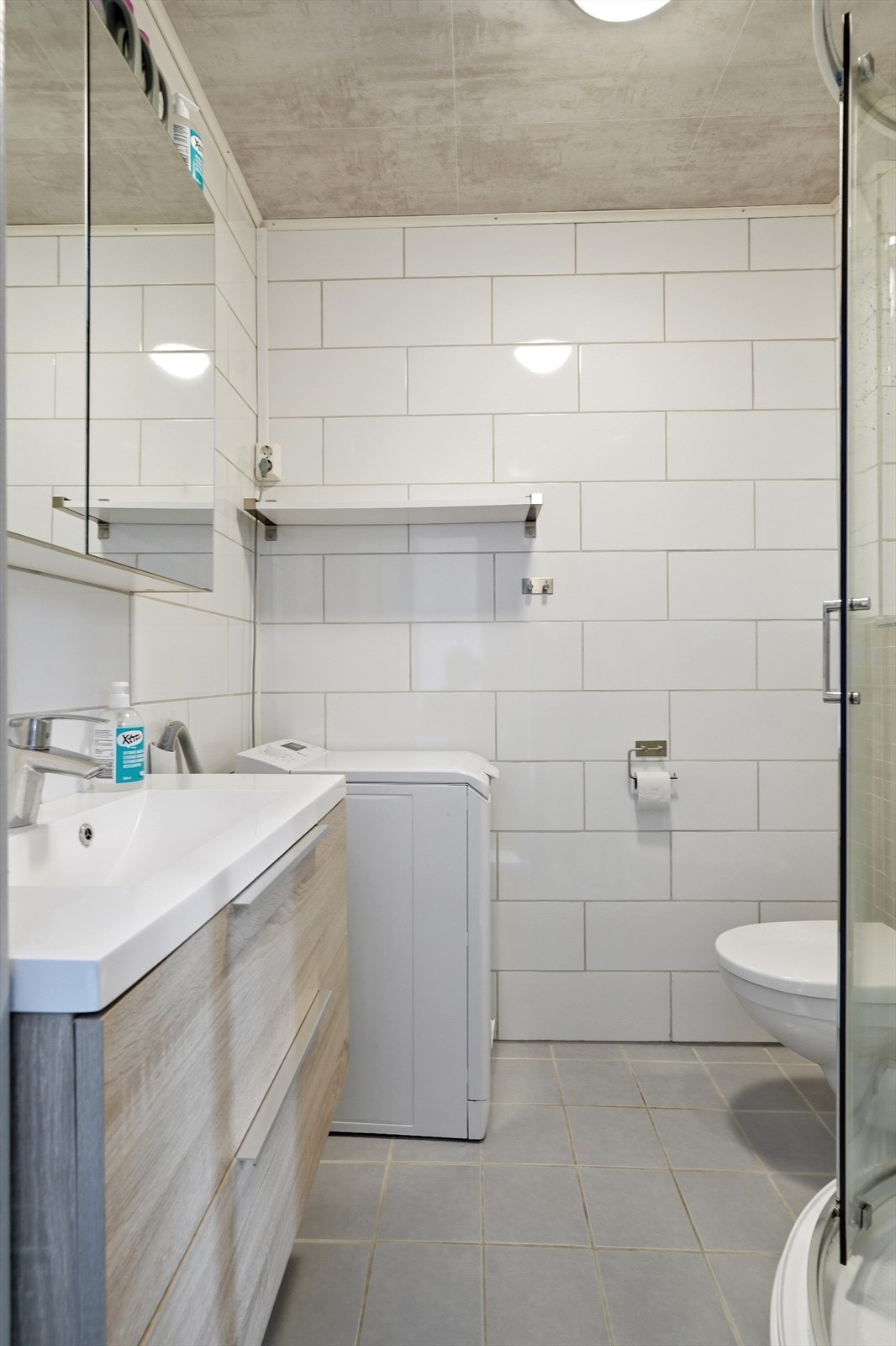 Badet har flislagt gulv med varmekabler, dusjkabinett og opplegg for vaskemaskin. Oppusset i 2017. Galleribilde