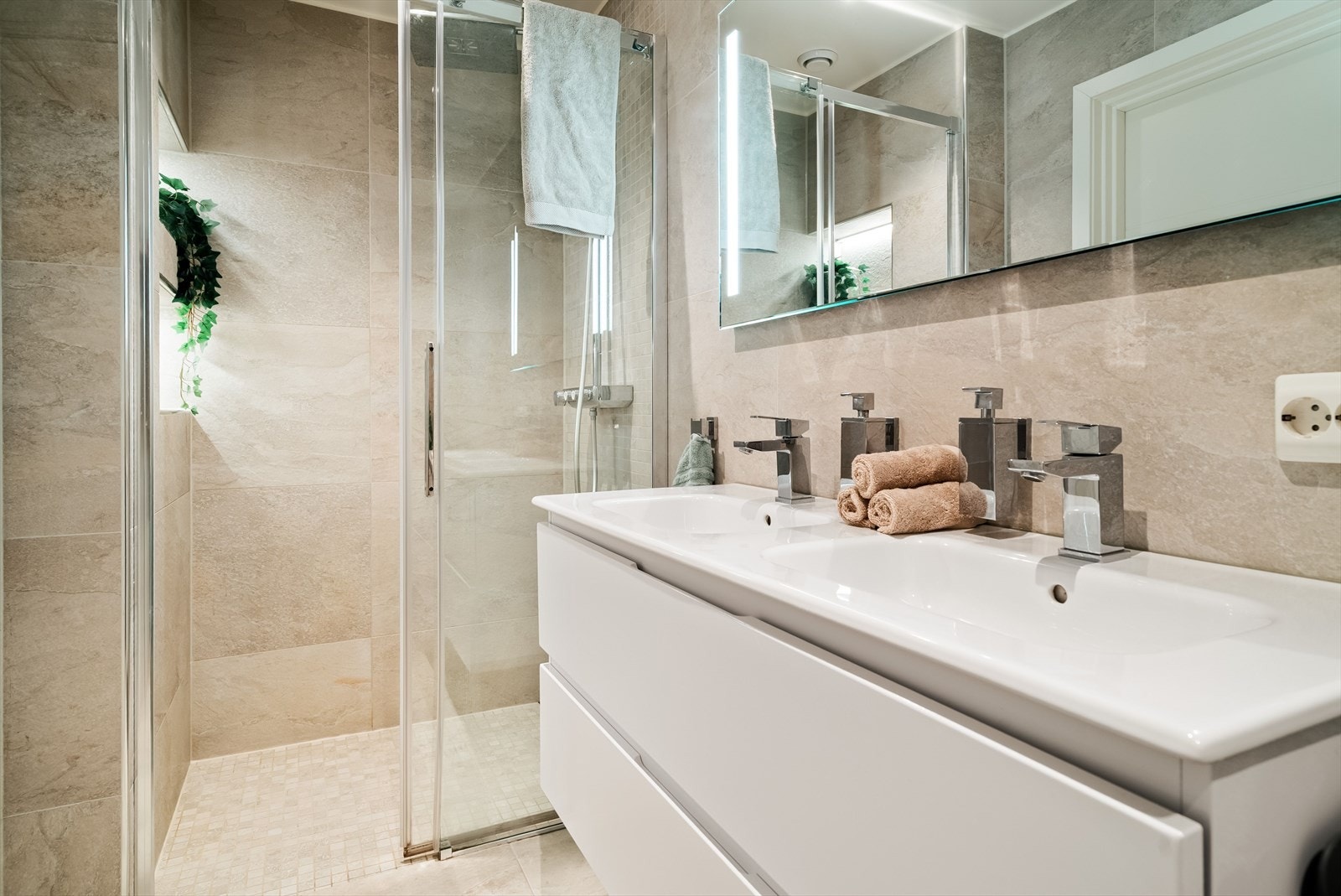 Badet ble renovert i 2020 med stilrene fliser, dobbel servant og en romslig dusjnisje. Galleribilde