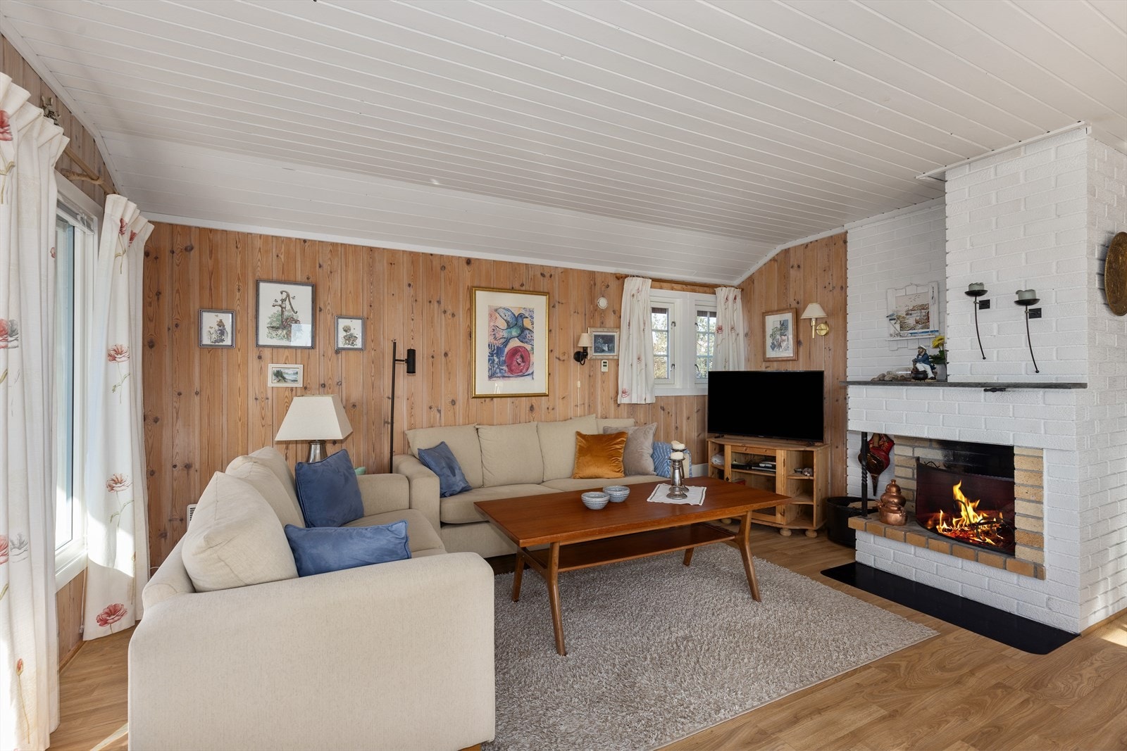 I stuen er det åpen peis og montert en nyere panelovn. Galleribilde